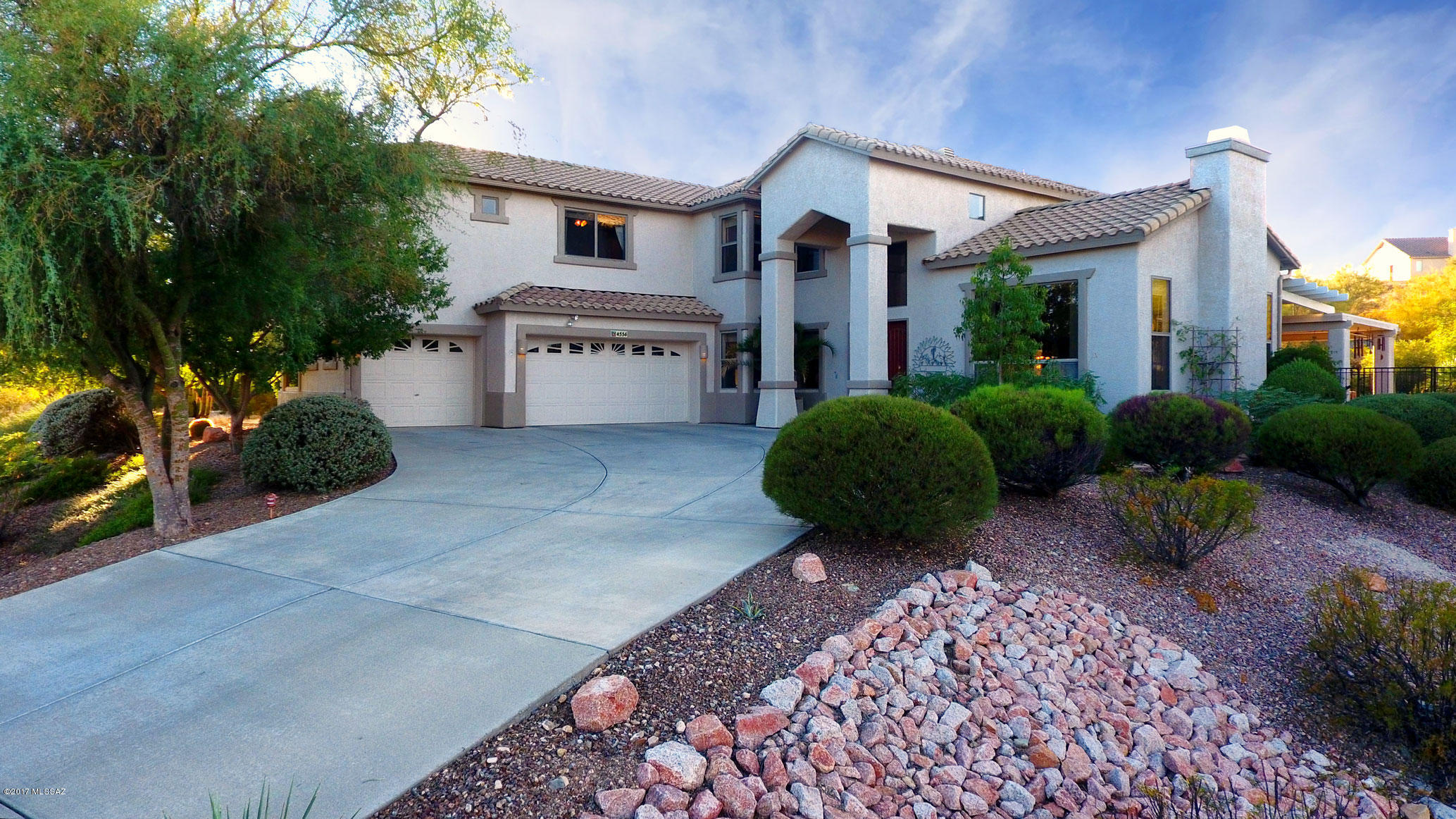 A statuesque entry welcomes visitors to this gracious home on a gentle hill in Tucson’s actively growing & glowing West Side. Views of the Catalina Mountains and our lushly green Sonoran Desert abound from the bountiful windows throughout the home. Welcoming from the moment you enter, it’s conducive to family and friends’ enjoyment and relaxation-think watching the Super Bowl from the spa in February! The entry is graced with an elegantly curving staircase; the (original) owners have delighted in seeing their daughter descend those stairs in her first prom dress and later in her wedding dress. A small living room (more like a sitting room), warmed by a delightful fireplace and wrap-around windows, is a cozy spot for a chat. The lovely dining room, with coffered ceilings and windows overlooking the pool, can easily extend into the large entryway for holiday banquets. The entryway is accented with a charming artisan-crafted multi-level fountain. The "heart of the home" is the spacious open kitchen/family room/casual dining area, all overlooking the fabulous and very private rear yard. The kitchen has gorgeous chocolate-brown granite tile counters, a large island with a raised seating area and deep counters, Jenn-Air double ovens, Bosch dishwasher and tons of storage with pullout drawers, augmented by a generous shelved walk-in pantry. A full bath, terrific laundry room with sink and storage, and a guest bedroom complete the downstairs of this very livable home. The rear yard is a lovely landscaped oasis with a generous covered area, free-form pool with self-cleaning pop-ups and a delightful water feature, and an outdoor kitchen with large rotisserie/grill, refrigerator and bar seating. It's marvelously serene and private, with an excellent surround-sound music feature. Back inside and up the lovely curved staircase, one finds a wonderfully comfortable additional family area with built-in entertainment center and plenty of room for a wrap-around sofa and plush comfy chairs. Double doors lead to the spacious master bedroom with lovely open views in all directions and overlooking the pool. With two large walk-in closets, a huge glassed-in shower, soaking tub, double vanities with make-up area and a separate WC, the beautiful views are included at no extra charge. The remaining three bedrooms are spacious and all have walk-in closets. One bedroom is currently set up as an office with handsome built-in desks, shelving and storage along with marvelous Catalina views. The owners have made many upgrades costing nearly $30,000 in the past year, listed in the Documents section of this listing. AND let's not forget the wonderful quiet neighborhood, all large well-separated lots (minimum 1 Acre) but a friendly area where neighbors know and look out for each other. Great schools and shopping are nearby, there's easy access to downtown, U of A and lots of good restaurants and cultural events, new development of shopping and dining possibilities just down SIlverbell, and the new Tucson Discount Mall just a few miles away. So what are you waiting for, y'all come on over! Current appraisal of $510,000 available upon request. This home is listed below appraised value!!