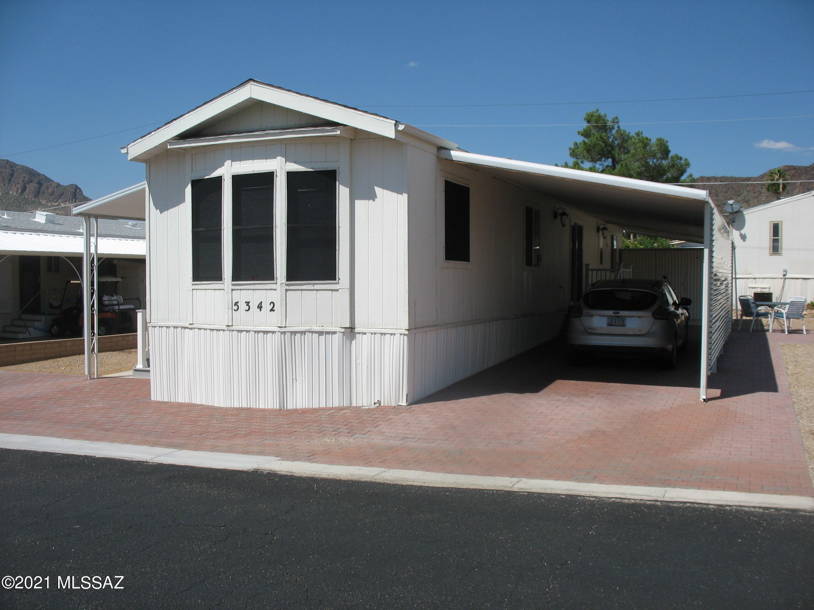 Very nice furnished 1992 single wide in great condition on a large lot!  Paver patio and driveway extends across front of home.  Nice Trex deck and sitting space on west side.   Open light and bright living room to large kitchen with lots of cabinet space.  The low $149 HOA fee includes unlimited golf, tennis, pickleball, shuffleboard, 3 pools, spa, exercise room, trash collection, and a lot more. Also included is the full use of separate buildings for card games, billiards, dances, concerts, educational forums, church services, and other social gatherings.  Tucson Estates is a safe and caring community.  You own the land, no lot rent!