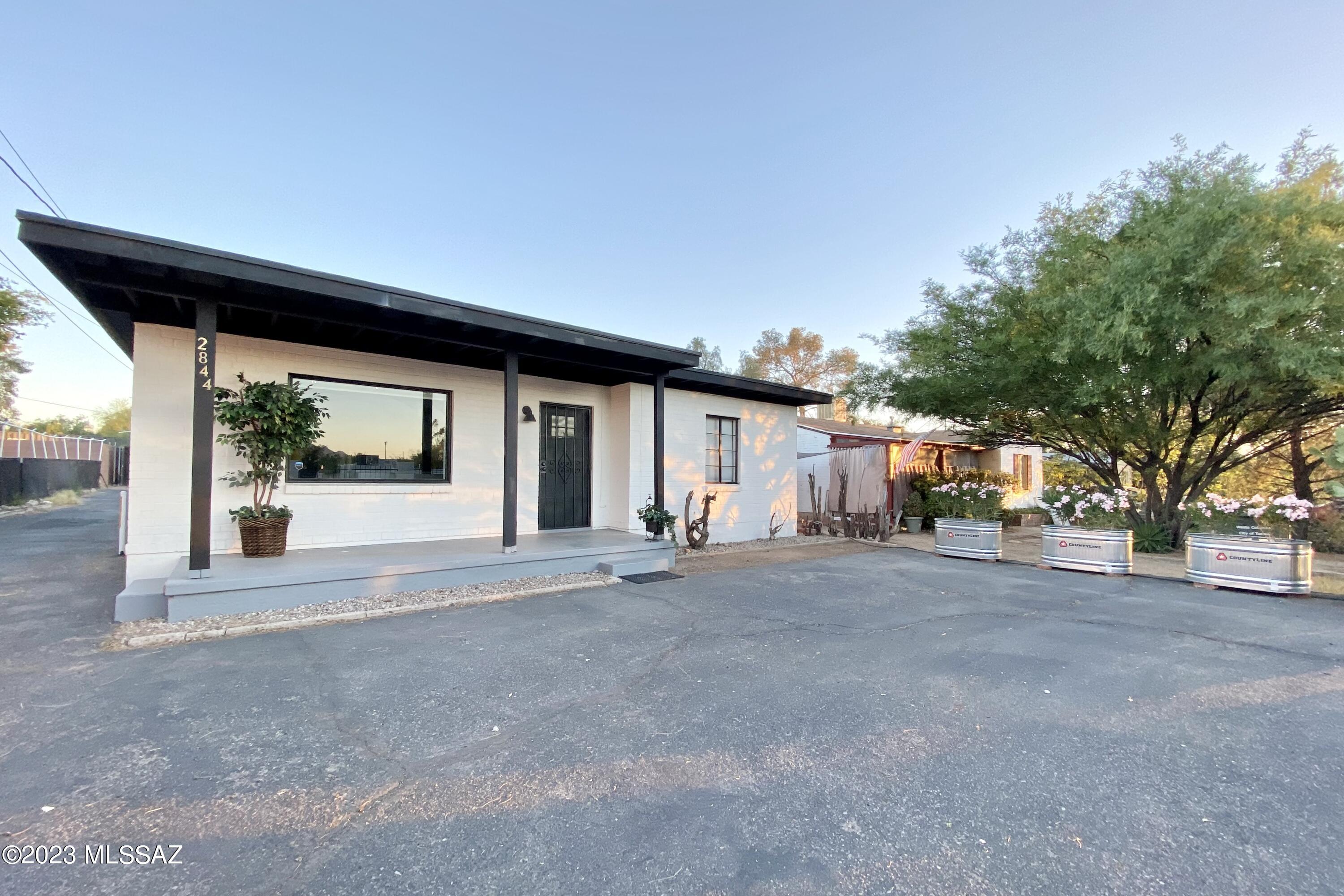 RARE Opportunity to Own 2 Homes in a Historic Neighborhood! Remodeled 3 bedroom, 2 bath main home with den (1425 SF) PLUS 1 bedroom, 1 bath guesthouse with private backyard and separate laundry (484 SF)! This modern farmhouse home is amazing! The kitchen features Calcutta Quartz counters, subway backsplash, apron sink, custom cabinets, and more. The bathrooms and shower enclosures ooze style. Tile floors throughout both homes so there is not carpet! There's so much to love! Come. See. Stay!