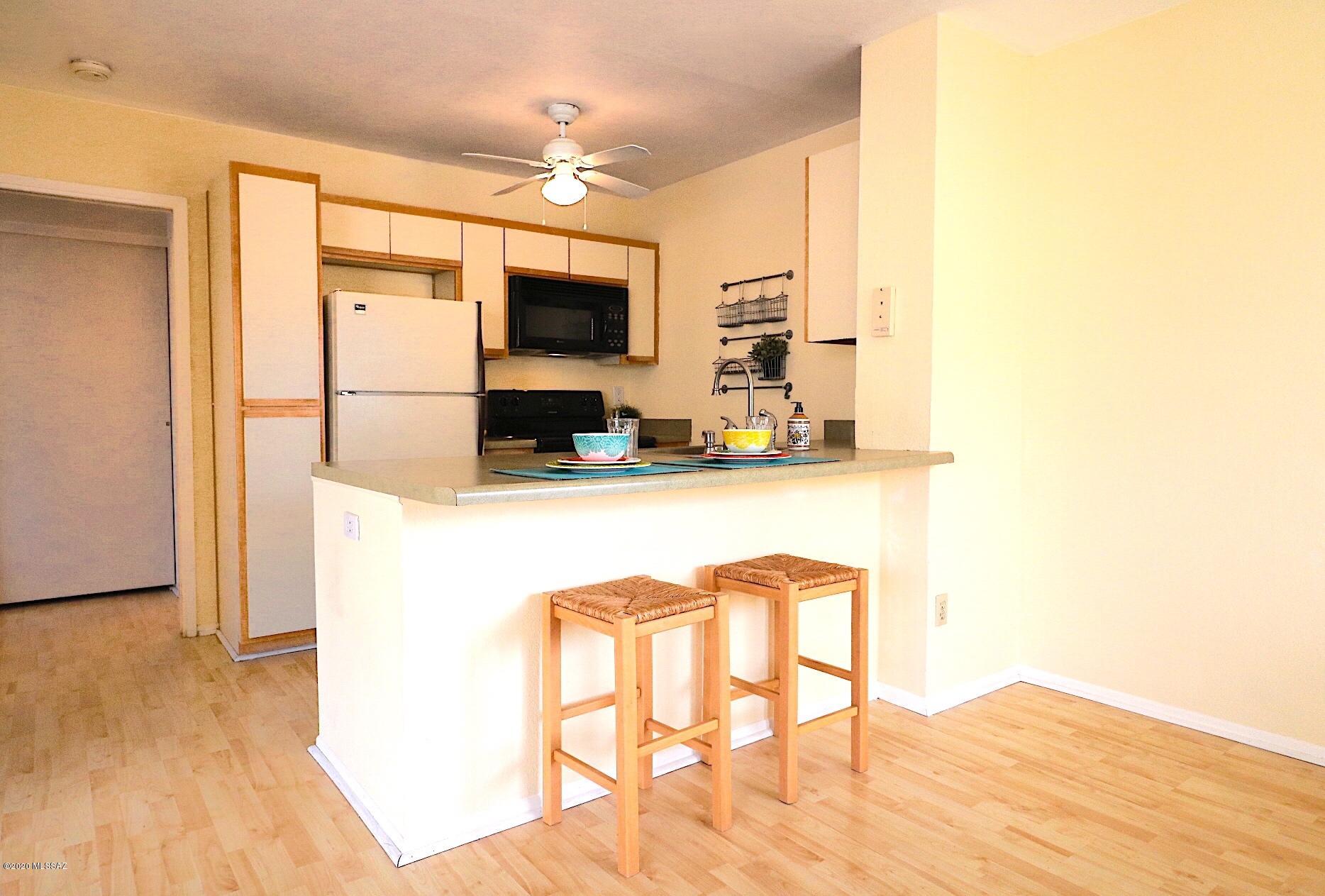 Cute Cute Cute! This second-floor single level 1bed/1bath unit has high ceilings and abundant natural light, making the space feel much larger than the actual square footage! No need to pay for laundry or hand wash dishes! Instead, enjoy feeing spoiled with your own stackable washer/dryer & dishwasher inside the unit. Kitchen has an eat-in breakfast bar, creating additional flex space for the dining room area, if desired. Soak up the beautiful Tucson sun while relaxing on your own private balcony, accessible from both the bedroom & living room. Entertain friends and family at the community pool, spas, & clubhouse, surrounded by the meticulously landscaped grounds. Close to Udall Park, Sabino Canyon Rec Area, shopping, food, & entertainment. Unit has 1 designated covered parking spot.