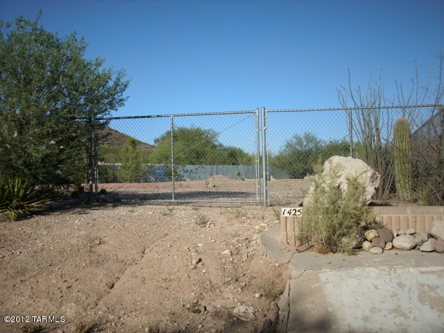 PRICE REDUCED! Front row seats for A Mountain fireworks from lovingly landscaped parcels just south of Tumamoc Hill. 2 R-1 lots (addressed 1425 & 1415 S Camino Del Sierra) are totally fenced as one, with 6' chain link and corrugated steel fencing. They are being sold together. Tax amount & size info is total of BOTH. Joint sewer agreement between the two parcels. Properties hold multitudes of ocotillos, agaves, other cacti and metal sculptures, and large mesquite trees too, but large cleared area awaits your custom home.