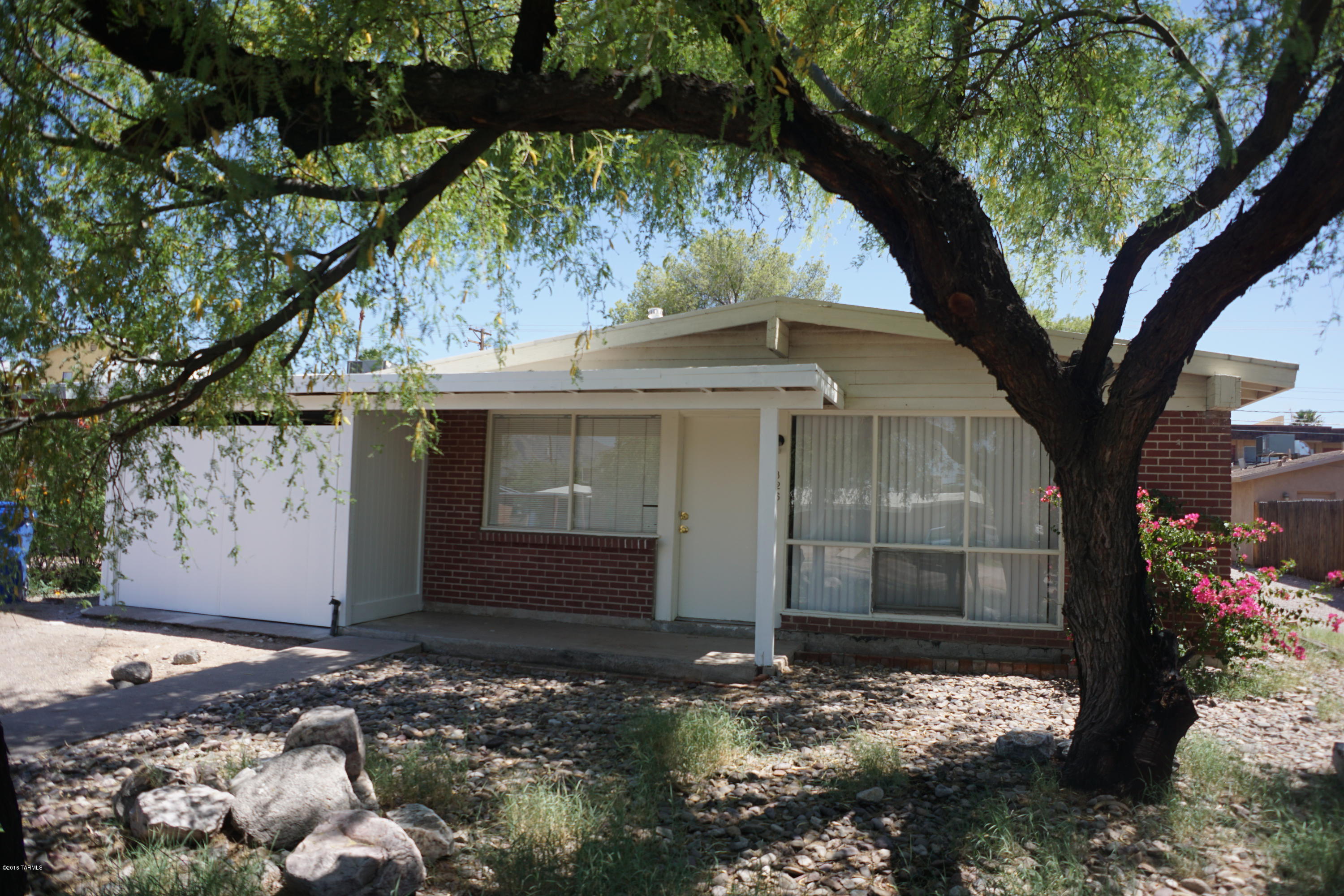 Central Tucson Bungalow, Red Brick 3Bd/1 Bath home close to everything! Separate Living room, Kitchen with gas range and dinette area. Ceiling fans, tile/carpet. Front porch, covered  back Patio.  Huge fenced backyard, low care landscaping. Evap cooling, 2 car garage, w/d hookup, within biking distance from UA.