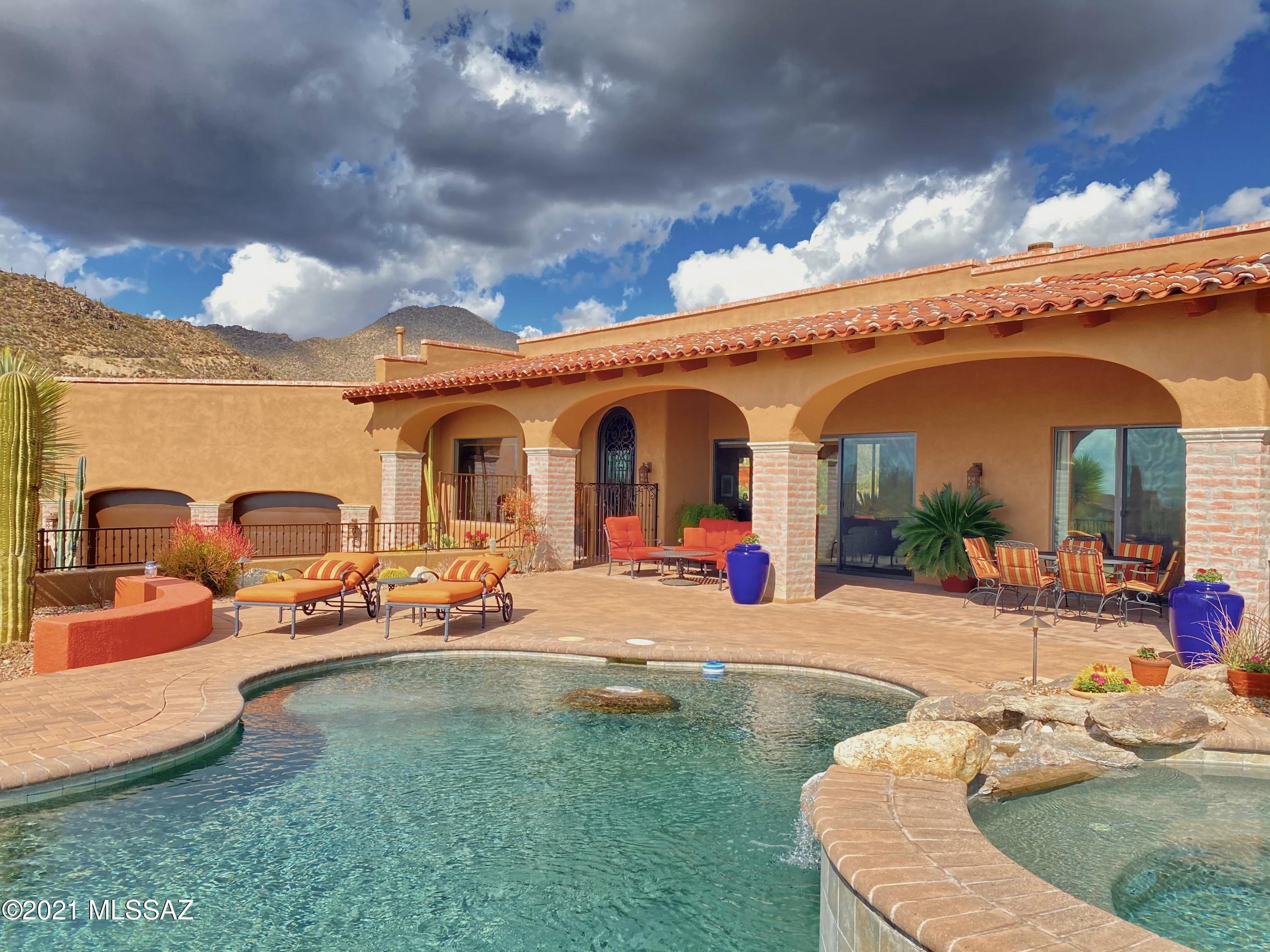 Stunning SW Territorial home perfectly situated in Canyon Pass to capture PANORAMIC VIEWS!  Perfectly oriented on the lot to maximize privacy & views. Two patios offer options to enjoy any time of day, night or season.  Front patio offers pool, spa & sweeping sunsets & Marana valley lights at night. Back patio includes fireplace, built-in bbq and backs up to mountain with canyon views. Interior features reflect top-notch quality throughout: Spacious open floorplan with gourmet kitchen that opens to great room. Perfectly set up for entertaining. Living room has stack-stone fireplace & wall to wall sliders to take in the view.  Roomy master retreat w/ fireplace and luxurious bath, custom built-ins & huge closet. Generous private guest bedrooms all have ensuite bath. One is an attached casita
