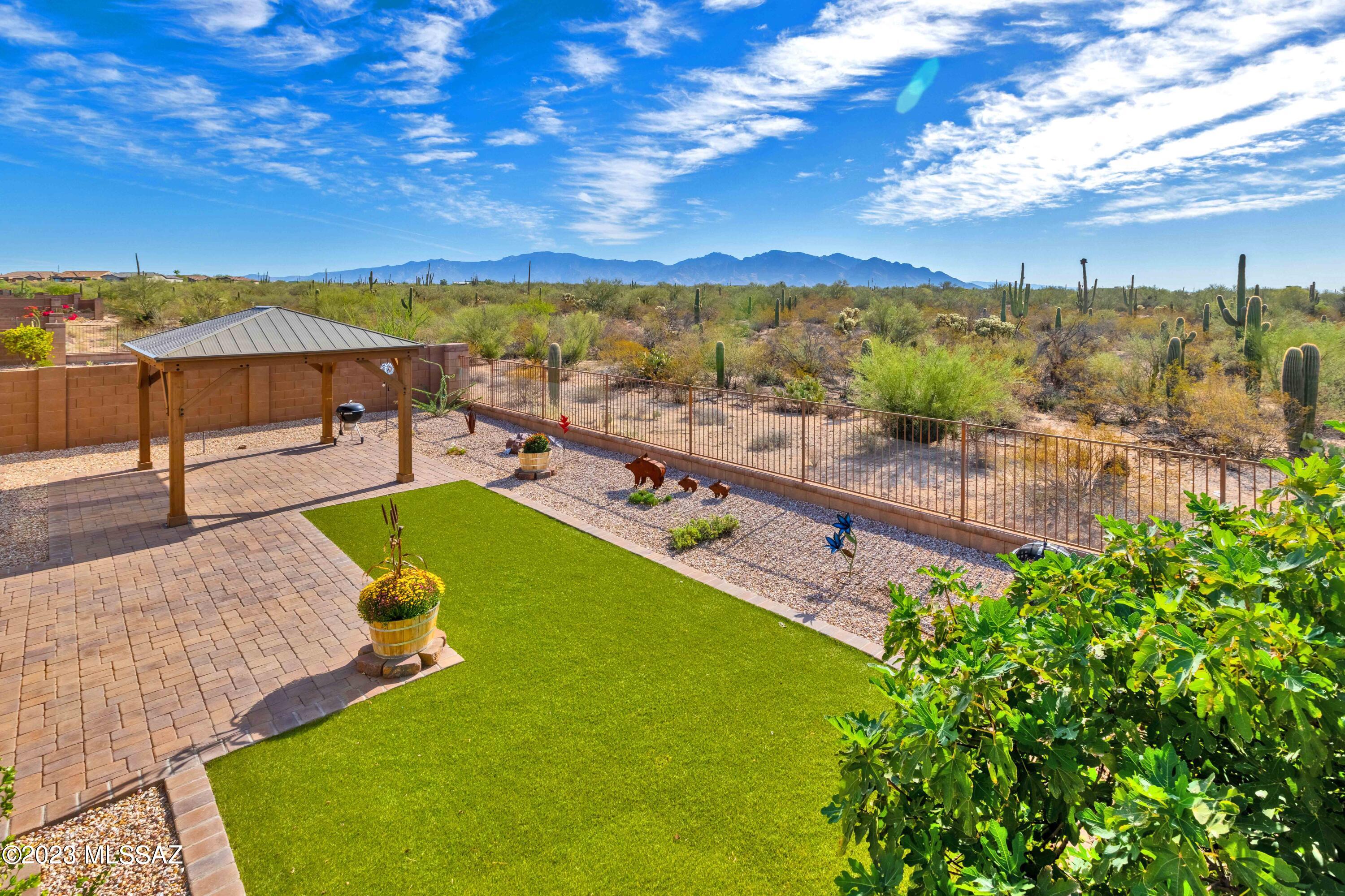 This stunning single story desert oasis offers unparalleled blend of luxury interior space and natural majestic Catalina Mtn Views all in an exclusive gated neighborhood. As you step inside you'll be greeted by an open and inviting floorplan with 10' ceilings and 18'' tile throughout, providing seamless flow between spacious living areas. Say goodbye to carpet!  The heart of this home is the Stainless Steel Gourmet Kitchen boasting double ovens, gleaming quartz countertops & top of the line Kitchen Aid appliances.  A massive walk in pantry ensures you have plenty of storage for all your culinary needs.  This home also features not one but two Owner's suites, each offering it's own unique charm. The primary Owner's suite features an elegant walk in shower while the 2nd Owner's suite offers a comfortable seated shower, its own large 17'x11' living room, separate heating and cooling & private courtyard entry, creating a private guest quarters OR muilti-generational living arrangement.  Plus this home has an additional bedroom with it's own en-suite bathroom perfect for guests. Work from home? No problem! This home also includes a spacious den, providing the ideal workspace.  Enjoy the convenience of a 2-car garage & separate 1-car garage, perfect for extra storage or a workshop. Speaking of storage, there's an additional 13'x7' storage area in the 2 car garage, providing even more space.  A private gated front courtyard offers a serene place to unwind & the lovely backyard features a custom pergola to enjoy the expansive Mtn views!