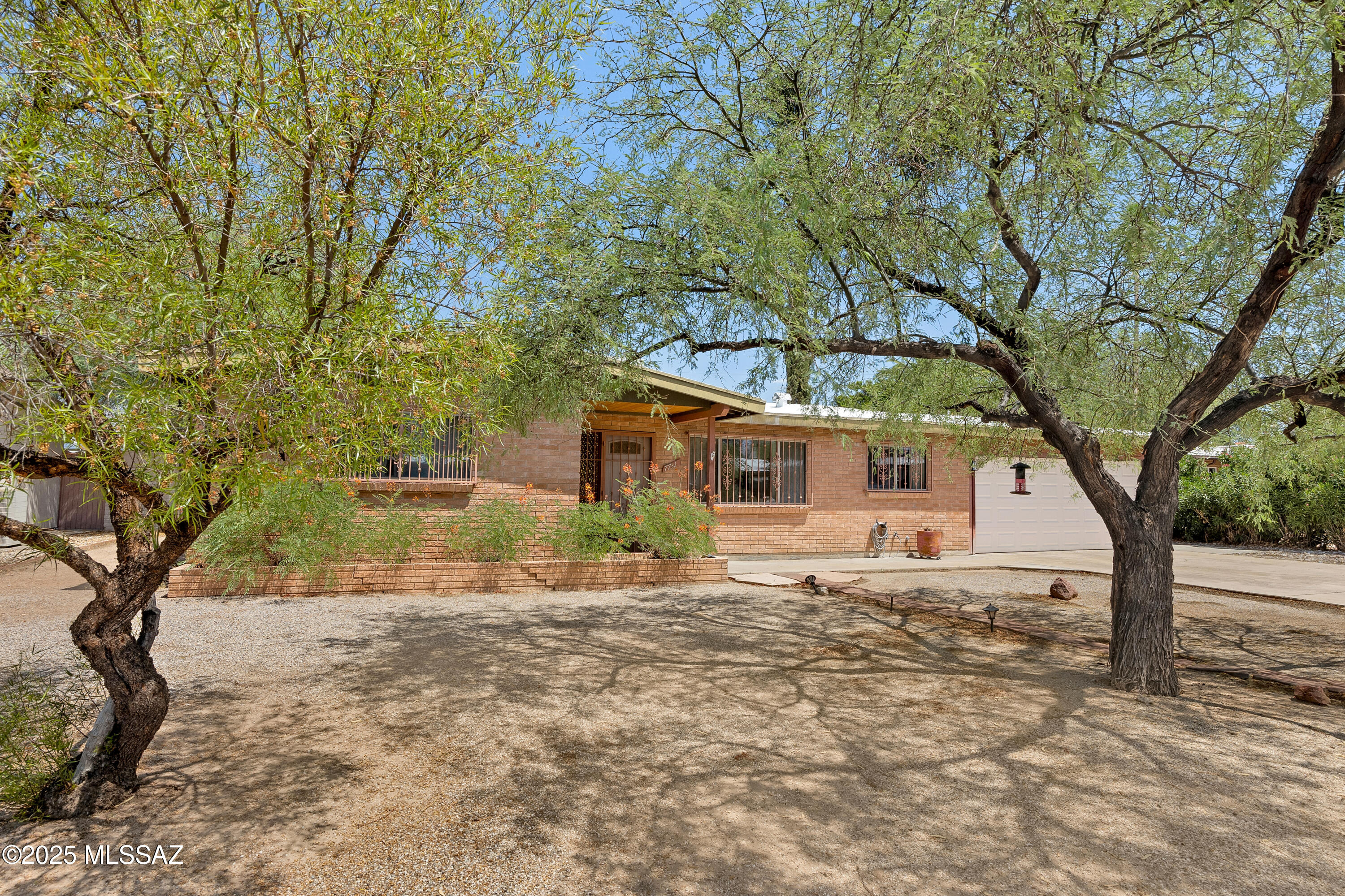 Live the Eastside dream in Silver Shadows Estates! This charming 3-bedroom, 2-bath, 1,830 sq. ft. solid brick home sits proudly on an oversized ¼-acre lot with no HOA-giving you the freedom to bring your RV, recreational toys, or big future plans. Inside, the upgraded kitchen shines with rich granite countertops, stainless steel appliances, and plenty of workspace for cooking and entertaining. The primary bathroom has been completely remodeled, featuring a sleek vanity with quartz counters, a gorgeous floor-to-ceiling tiled walk-in shower, and thoughtful ADA-friendly modifications for accessibility. The open floor plan and spacious bedrooms create a comfortable, inviting layout. A pass-through fireplace serves as a warm, eye-catching centerpiece between the living spaces, while the enclosed Arizona room offers year-round enjoyment and extra living space. Step outside to a clean slate backyard complete with a small workshopideal for hobbies, storage, or creative projects. The expansive covered patio is the perfect spot to relax and enjoy Arizona's beautiful evenings. Located just minutes from shopping, dining, entertainment, and the popular Udall Park, this home offers both convenience and opportunity. Aggressively priced and brimming with potential, it's a clean canvas ready for your personal touches. Don't miss your chance to own this versatile Eastside gemschedule your showing today!