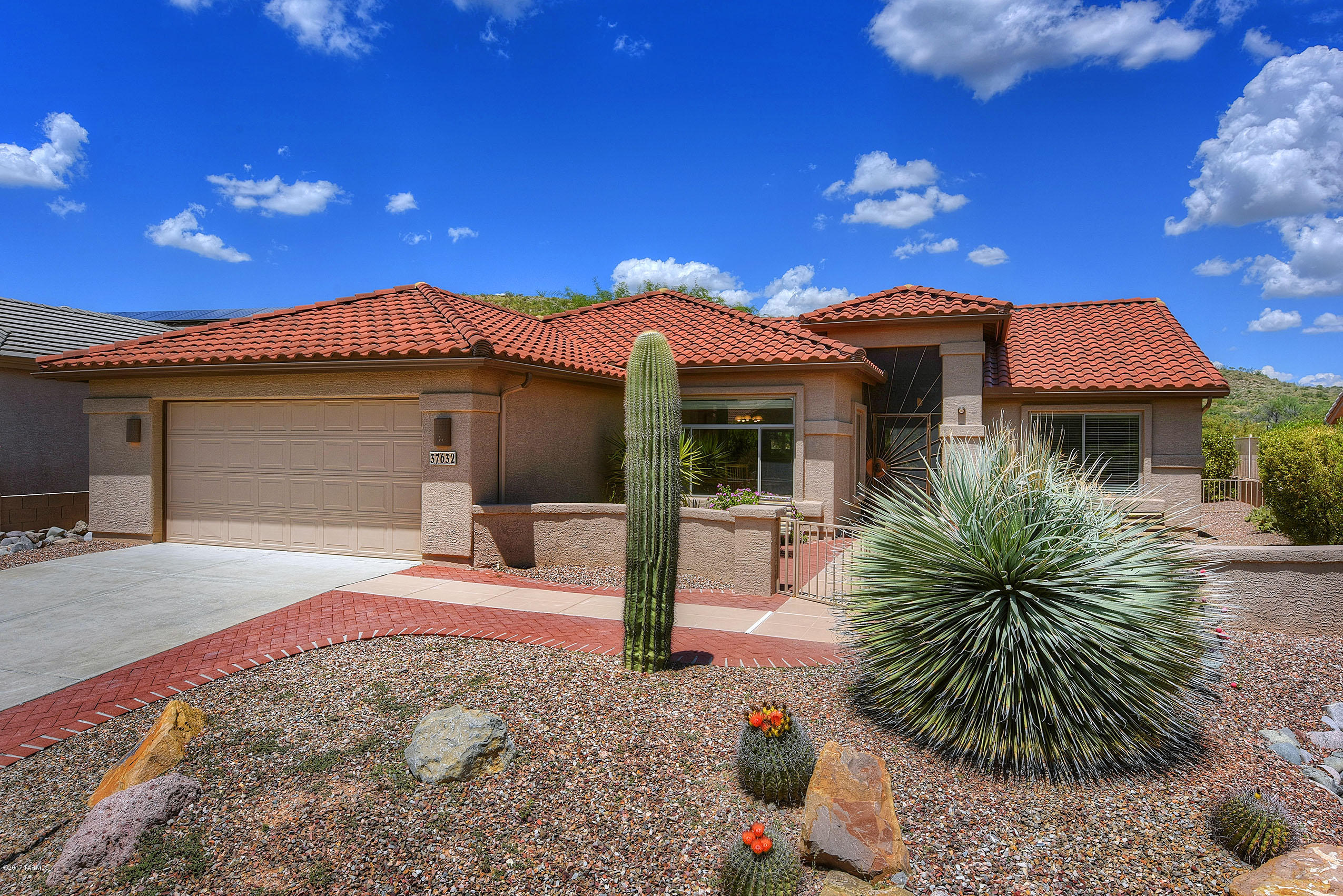 Lovely Expanded Laredo Offering Catalina Mountain Views to be Enjoyed from Your Brick Paved Front Courtyard.   Enter Your New Home Through Custom Designed Entry Gate Ready to Relish The Open Concept Living of Vaulted Ceilings, Great Room with Freshly Painted Entertainment Center, Bee Hive Fireplace, Large Eat-in Kitchen With New Stainless Steel Appliances.  Master Bedroom has More Than Enough Room for King Bed and Opens to Master Bath with Dual Sinks and Ceramic Tile Floor, Walk-in Shower & Walk-in Closet. Guest Bedroom Side of Home has been Extended 2 Extra Feet Giving Added Dimension to Office / Den. This Location is Ideal for Walking to Shopping Center or Driving Golf Car to Clubhouses for Dining Out