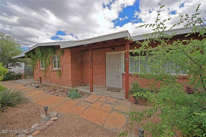 Attractive wire-cut red brick Palo Verde home in move-in condition! Open architecture, open LR/DR/KIT great room, pitched ceilings, light and bright.  Wood burning stove fireplace in LR, tile floors throughout except for 2 of the bedrooms which boast new carpeting.  3 BR/ 2 BA (1 of the bedrooms has double French doors and makes a great office).  Kitchen with breakfast eating area, upgraded countertops and cabinetry, recessed lighting, upgraded electrical, ceiling fans, all appliances included.  Pretty and private fenced backyard, watering system, Malibu lighting, convenient area close to Blenman Elementary School, Catalina High and UA!