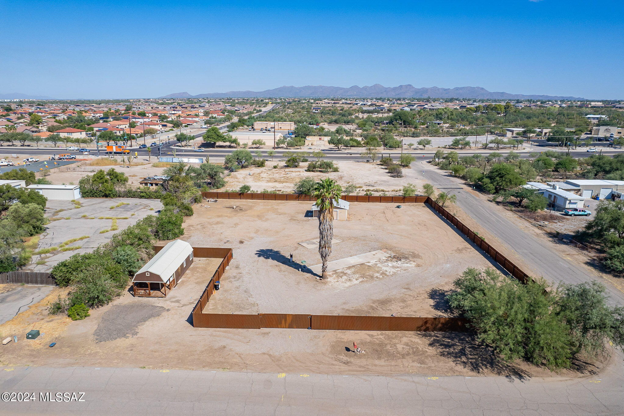 Bare land corner lot opportunity! Secure and private 1.26 acres off 1-10, Cortaro Farms Road in NW Tucson. Fast growing area close to shopping and so many other amenities. Property includes 2 accessory shops. One 14 X 40 shop(currently no electricity) at front left of fence with parking area and 2nd interior storage shop with potential for plumbed bathroom upgrades, electricity to structure. Existing RV pad and hookups. Marana City water. Gas and electric on the property. Sewer is currently septic, but city sewer is available. Wrought Iron Corrugated 6' Privacy Fence included. All improvements and structures convey. So many possibilities. Clean and move on ready. See attached SH Suburban 18.19. zoning description on MLS Disclosures.