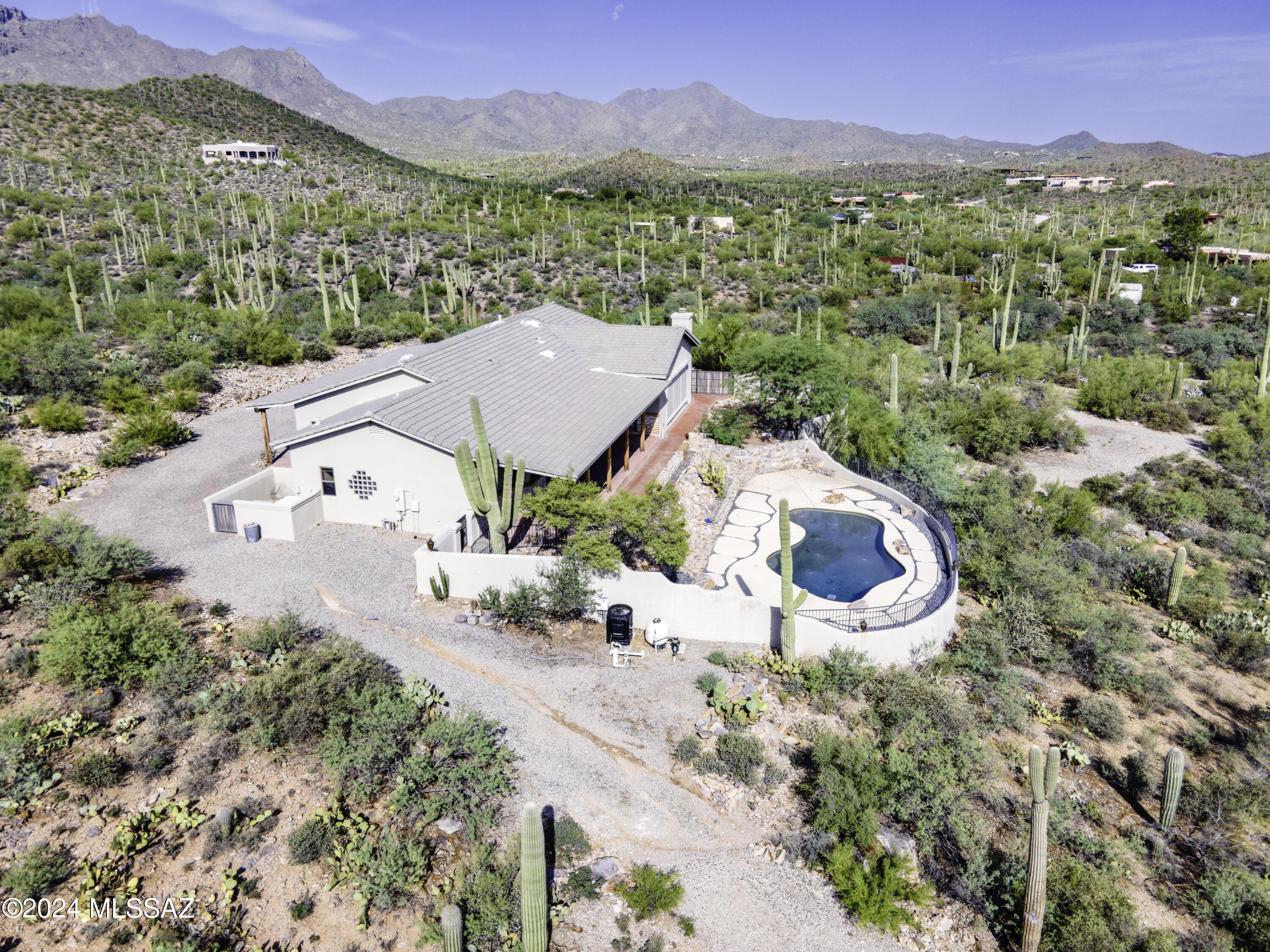 Charming Desert Jewel! Experience tranquility from this tastefully designed Santa Fe retreat surrounded by Bold Biews of saguaros, mtn., & city views!  A true nature lover's delight with touches of old world charm. Nestled on over 3 acres of land, this gem offers a sparkling  pebble tech pool, private driveway, 2-car garage with workshop, brick accents, & 2 long, extended covered porches. Interior includes natural light, neutral colors, wood beam vaulted ceilings, decorative light fixtures. plantation shutters, fresh paint, newly sealed Saltillo tile flooring, cozy beehive fireplace, newer cabinets, corian counters & brand new carpet. Entertain in the bright and airy living rm & fam, or host dinner in the formal dining room. Enjoy the expansive windows and rolling security shutters.