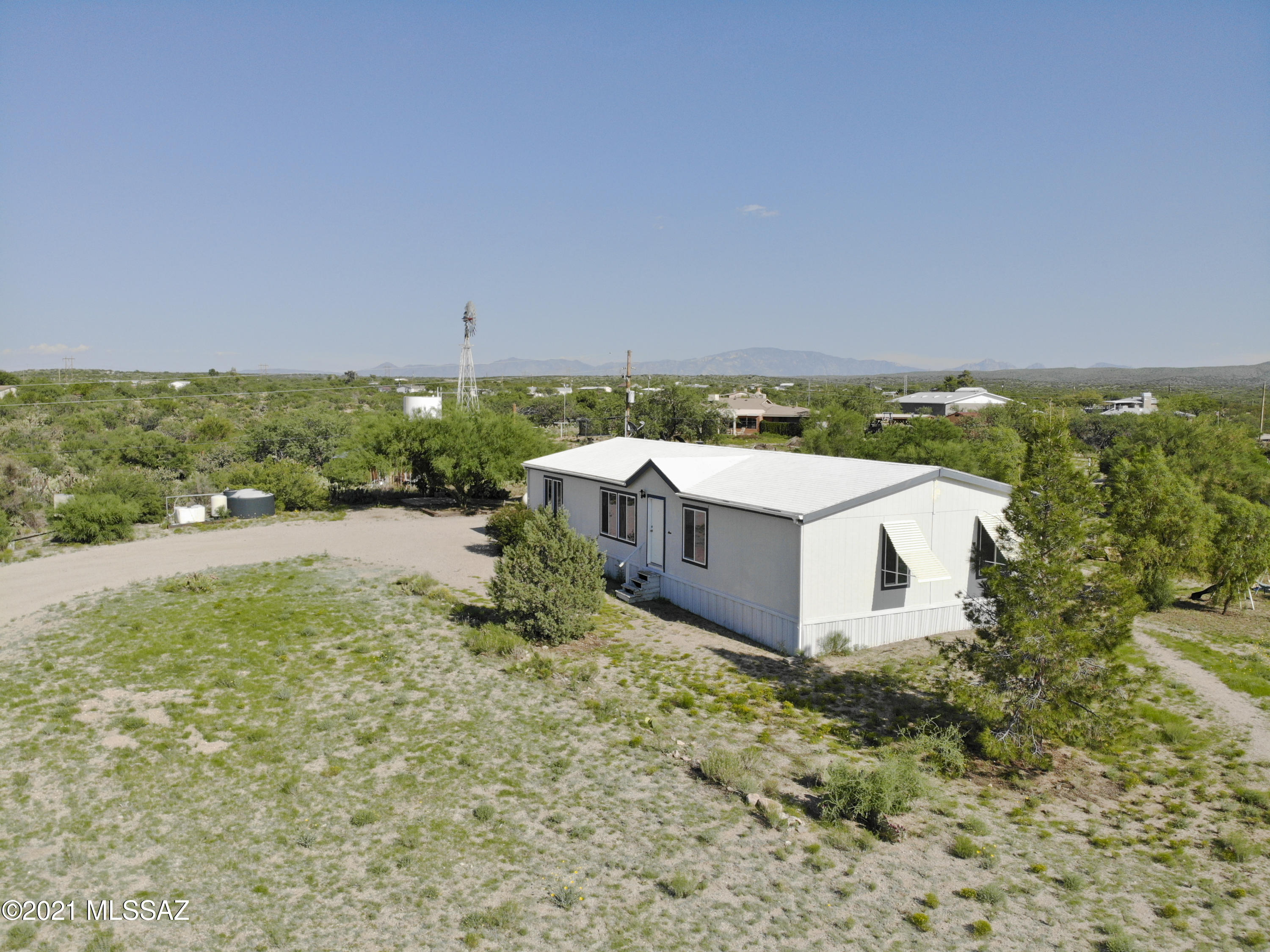 Enjoy Arizona country living on this 2 acre retreat with a stylish 4 bedroom & 2 bathroom manufactured home! This property will only be sold together with the neighboring 8 acre listing that includes another home, making this secondary home ideal for multi-family use, a rental property, or a future sale. The highly functional layout includes a well sized kitchen opening onto a large breakfast nook, with the larger family room nearby. A split bedroom floor plan delivers a spacious primary bedroom complete with walk-in closet & dual sink bathroom. Three additional bedrooms & a hall bathroom provide for flexible uses of these rooms. Additional workshop and storage buildings, plus room for expansion add to this property's value! No HOA and a very serene setting with so much potential!