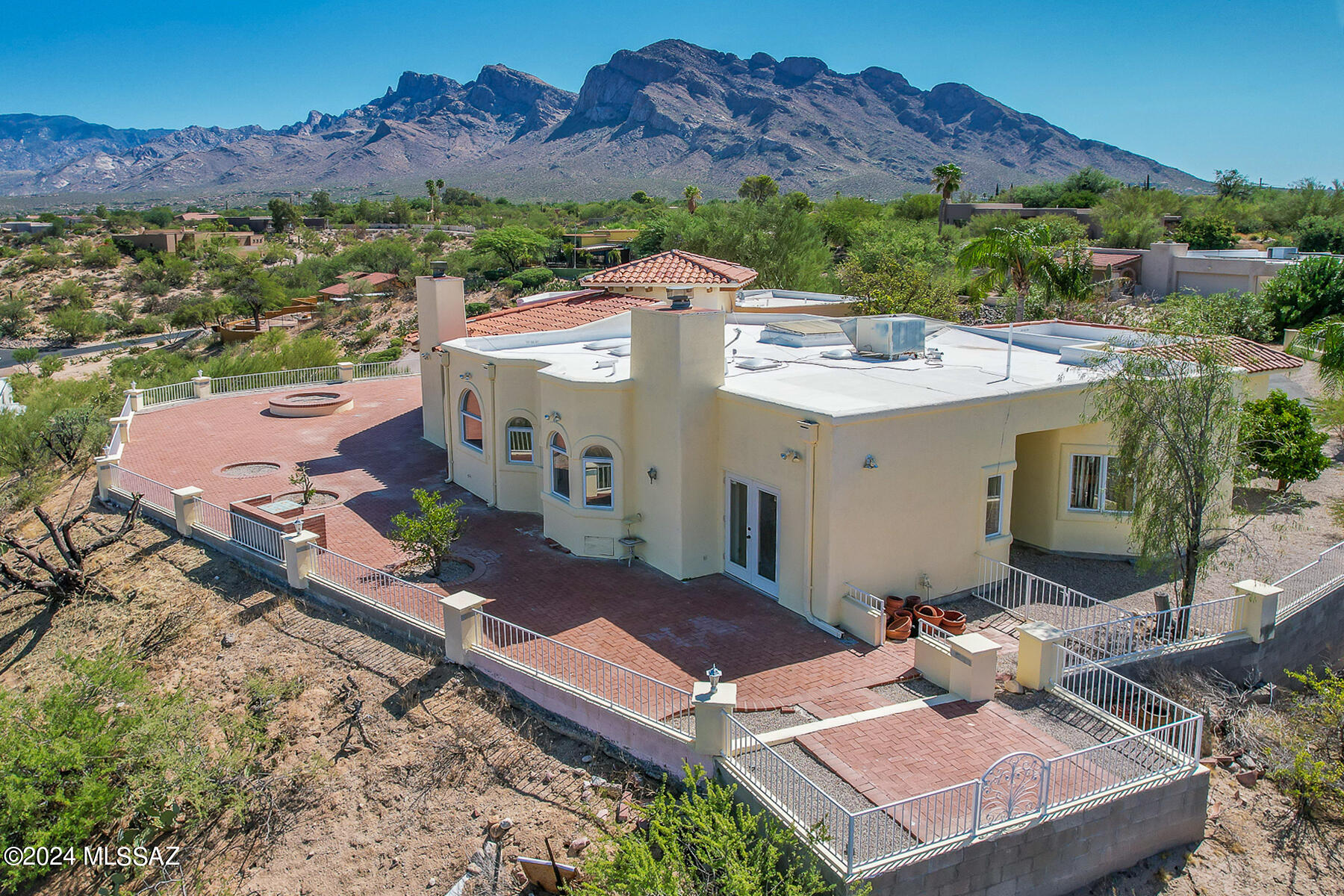 SWEEPING 360-DEGREE VIEWS can be enjoyed from this custom hilltop home situated in Oro Valley Country Club Estates. Residing on a .92 acre, cul-de-sac lot, this stately home offers uncompromising views of the golf course, twinkling Oro Valley city lights and sweeping mountain ranges. Spectacular 4BD/3BA (3,043 sf) home is accented by soaring, vaulted ceilings with wood beam accents in the spacious living room and Great room. Additional features include multiple light filtering skylights, 2 woodburning fireplaces, 3 bay windows, multiple French doors opening to rear veranda, plus a split bedroom plan with dual en suite bedrooms. Charming courtyard entry flows to inviting foyer with decorative inlaid tile, stained glass side panels on entry door, plus soaring foyer ceiling with stained glass clerestory windows. Beyond lies an impressive formal living room, formal dining room and Great room. Expansive chef's kitchen hosts dual skylights, center island, stainless appliances, work desk plus ample cabinetry and counter space. Owner's suite off veranda hosts a cozy fireplace, bay window, jetted tub with arched bay window, walk-in shower and dual sink vanity. Adjacent is a bedroom or office with wood plank flooring, wall-to-wall storage closets and upper built-in cabinets. Guest wing houses second en suite bedroom with shower & dual closets plus fourth bedroom with walk-in closet and hall bath with shower. Large laundry/crafts room has utility sink. Additional amenities include alarm system, outdoor security lights, zoned heating & cooling, drip irrigation system, 2 car garage with attached storage cabinets plus outer storage closet in atrium walkway. Ideal for entertaining, the sprawling rear veranda is highlighted by brick pavers, built-in planters and breathtaking views of the valley, golf course and mountain ranges. A true desert oasis within close proximity to nearby amenities including shopping, dining, golf, Hilton El Conquistador Resort, Oro Valley Aquatic Center and Catalina State Park.