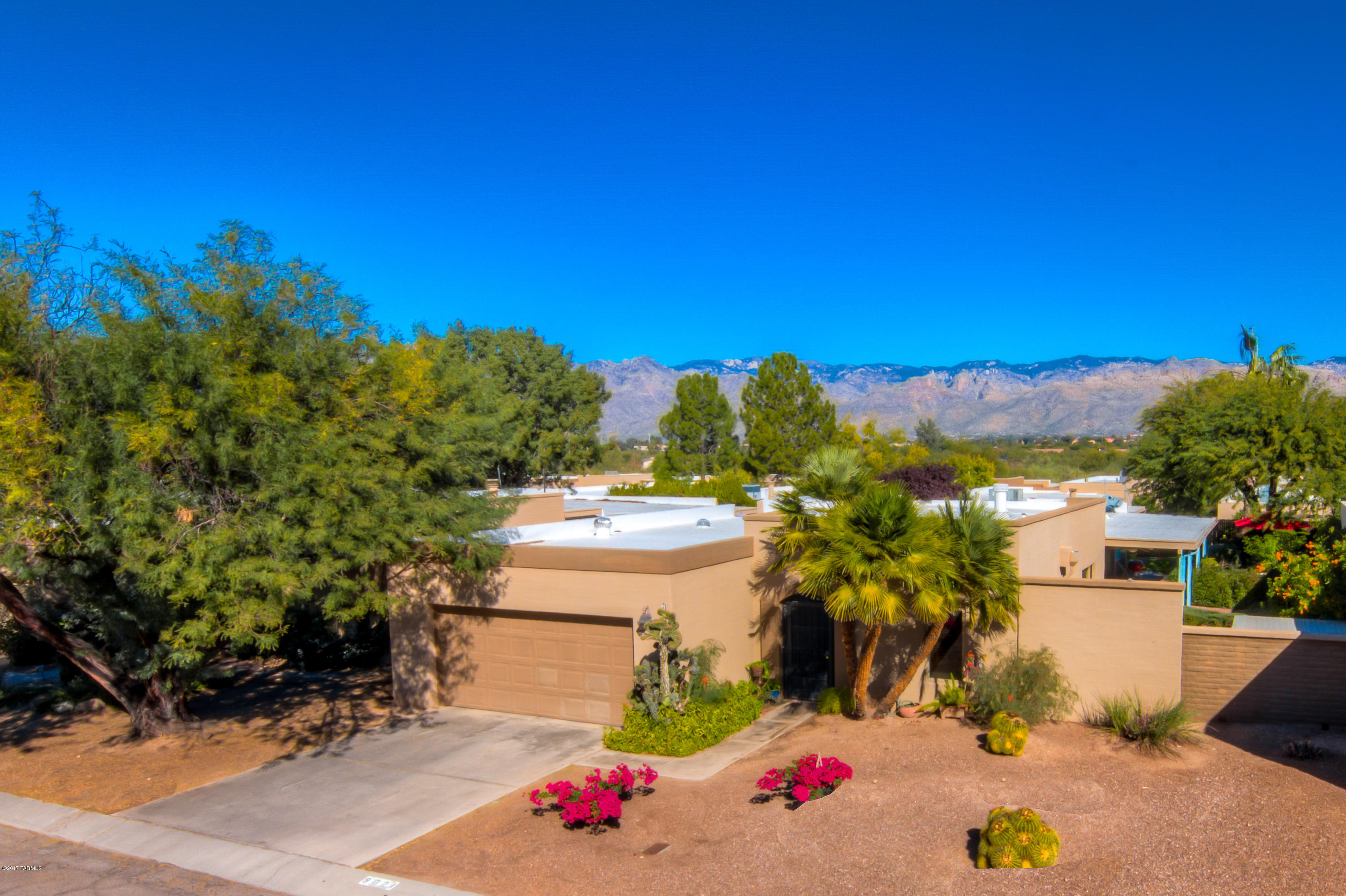 Beautifully updated home in Fountain Park/Acacia Park with mountain views! Lovely 4BR/2.5BA/2Car Garage home features a thoughtfully updated kitchen with slab granite counters, large island, spacious storage cabinets, & mosaic back splash. Enjoy wonderful outdoor living with the covered patio, gorgeous flowering garden, mature trees, patio seating, real grass and mountain views from the north facing back yard! Updated baths, solar tubes throughout, new water heater, elegant wood mantle on the fireplace, solid surface flooring--no carpet in the home. Updated lighting, ceiling fans throughout, plus some newer windows. Delightful neighborhood is tucked away, yet close to popular shops, restaurants & schools. Enjoy the community pool & playground plus easy access to Tanque Verde Wash trails.
