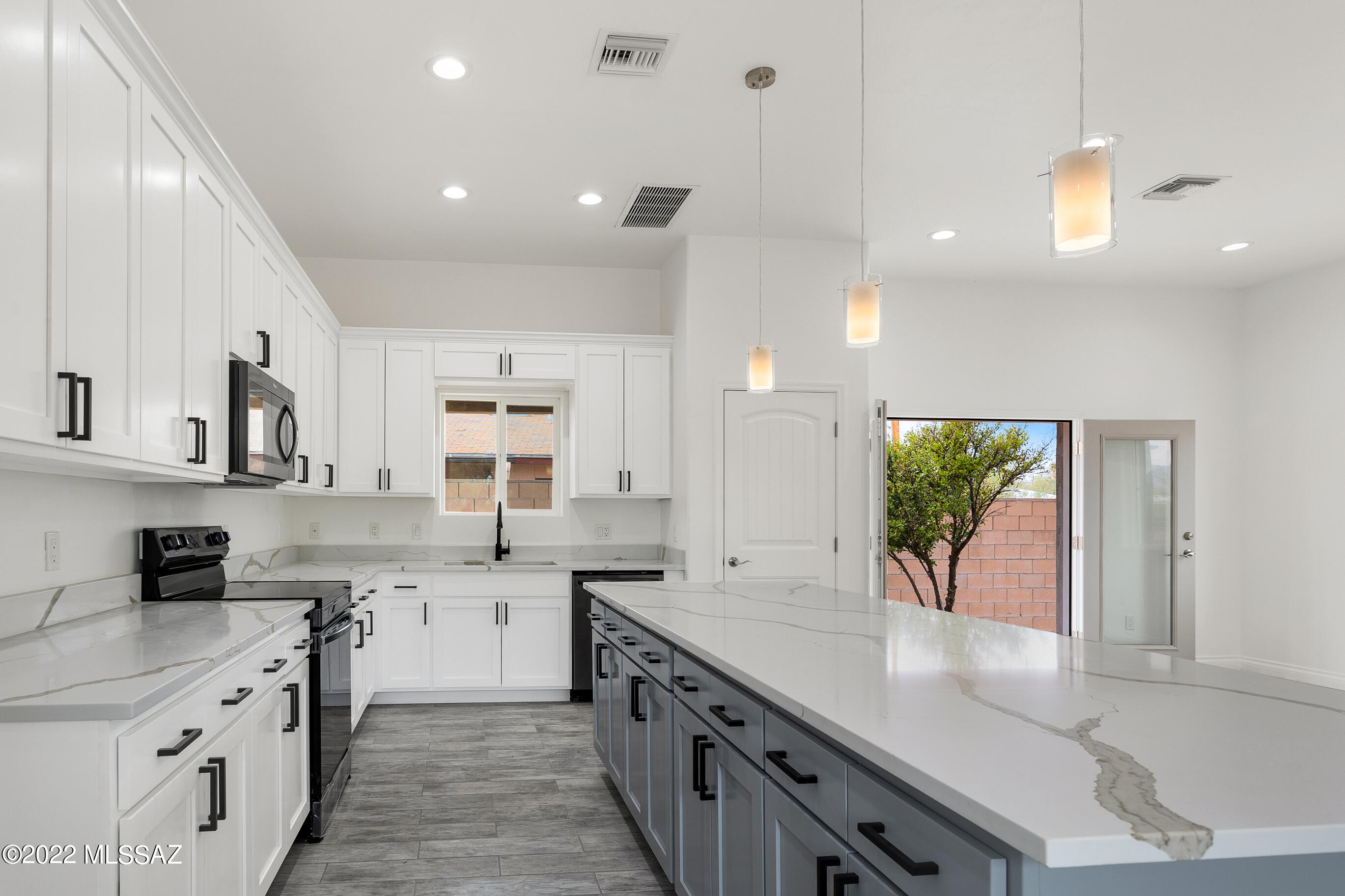 Newly constructed, unique contemporary home located in the heart of town, yet very private. Gated and set back from the road, this light and bright high-ceilinged 4BR, 3.5BA house has sensational Catalina views. Side entryway takes advantage of mtn views, opening to a spacious great room and open kitchen with stunning Bianco Levanto quartz countertops, black stainless appliances, 42' tall upper cabs and oversized island with a contrasting [color] base plus large pantry closet. Double French door access to side yard patio with fruit trees. Handsome wood-plank ceramic tile throughout home. Pass downstairs powder room to the light-filled stairwell to convenient upstairs large laundry room and 4 spacious bedrooms w/walk-in closets; 2 with in-suite baths and access to upper covered deck with views of the Catalina and Rincon mountains. 3 full upstairs baths sparkle with quartz counters and a huge tiled walk-in shower. Enjoy easy access to UofA and downtown with the peace of mind of knowing that everything from appliances, to energy efficient windows, LED lighting and Lennox 15seer HVAC is brand new!