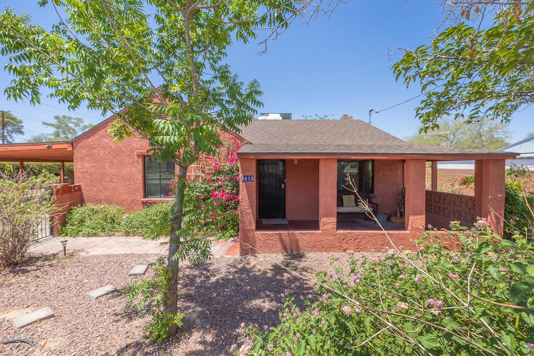 Charming 1940s mid town property with a HUGE backyard and beautiful, mature landscaping.  Covered front and backyard patios. Majestic Catalina Mountain views. Ample covered parking under 4 car carport. Backyard storage shed. This inviting home has 3 bedrooms, 1 and 3/4 bath, interior laundry, dining area, family room (with brand new laminate flooring), and extensive shingle roof work as of Spring 2020.  Come take a look for yourself. This property won't last long!