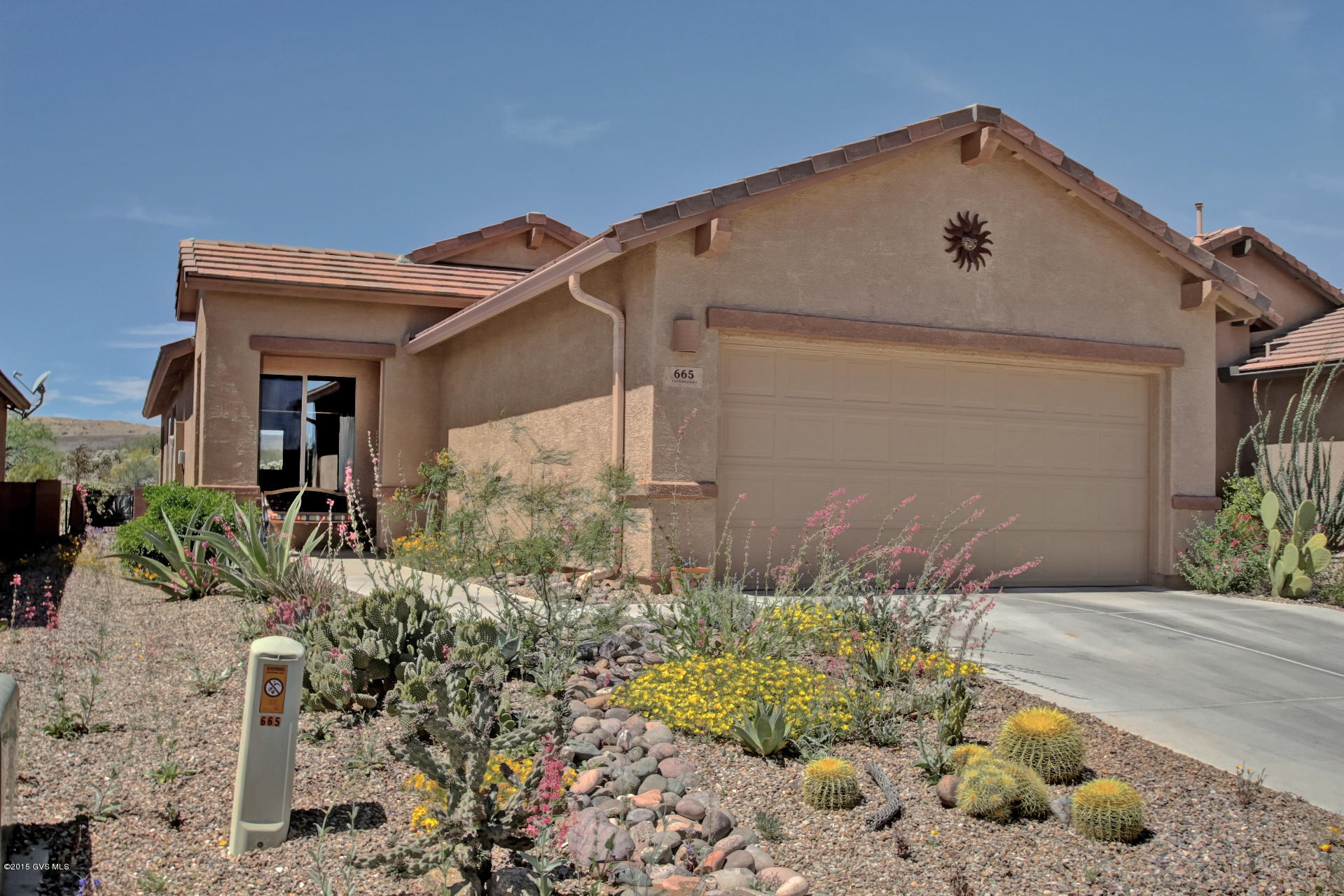 The perfect size home with an assortment of natural desert flowers to welcome you. Step into the foyer and follow the beautiful terra cotta floor tile into a brilliant great room with large windows filling the home with natural sunlight. The open den is a wonderful place to unwind at the end of the day to watch the beautiful evening sunsets. The kitchen has gorgeous hickory cabinets; sandstone tile backsplash; abundant counter space and a cozy breakfast nook. The master bedroom is very spacious and has an extended area for reading, exercising and more. Step outside and experience the botanical gardens featuring numerous desert garden islands and a lovely banco to relax. You'll love the location adjacent to natural desert hiking trails and hillside views. Come take a look!