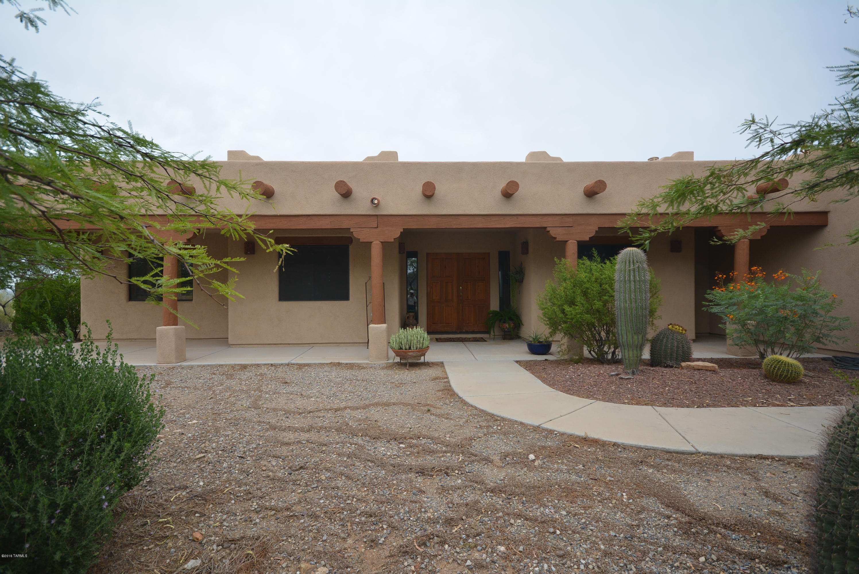 Thousands of acres as a back yard - unique opportunity bordering Saguaro National Park. Pristine protected city views, mountain views and of an enormous Sonoran Desert garden.  Very few homesites like this exist.  Impeccably maintained home with great room concept, huge picture windows, extra large porch and generous walled yard.  Clean and sharp on private gated road with horse facilities that include covered corrals and round pen area.  Trails to Saguaro National Park readily available for hiking or horses. Close to major shopping and I-10 with alternative route to Silverbell via Belmont Road.