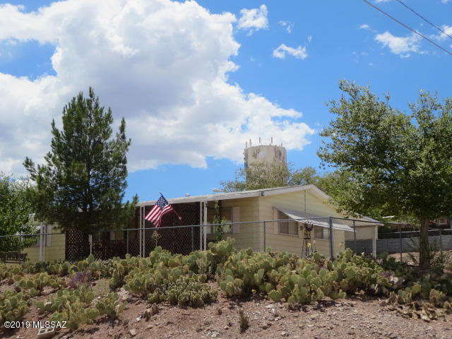 What a view!! Well maintained 3 bedroom 2 bathroom Manufactured Home on large corner lot in Benson, AZ. Spacious kitchen area with plenty of cabinets & counter space and a separate dining area that leads into the living room. From the living area you go into a wide hallway that takes you to the guest bathroom and 3 bedrooms. Off the kitchen area there is access to an attached tandem 2 car carport plus room to park an RV. The fenced  manicured yard has fruit and shade trees, a sitting area with a fire pit, room for a garden and a comfortable covered front porch to take in the beautiful views. Must see.