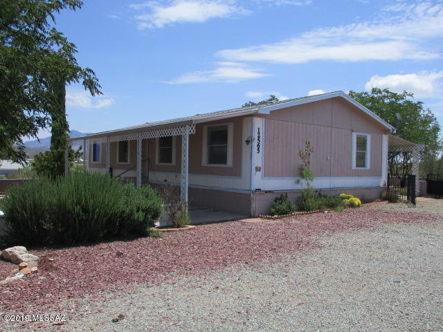 Breathtaking mountain views as far the eye can see surround this fully fenced one acre lot. A wonderfully landscaped front yard with decorative gravel and desert plantings.  A covered back porch looks out onto a lovely back yard, complete with a shed! This charming home could be a lovely getaway for anyone looking to live in there own beautiful Arizona oasis. Come and take a look at your new home sanctuary today!