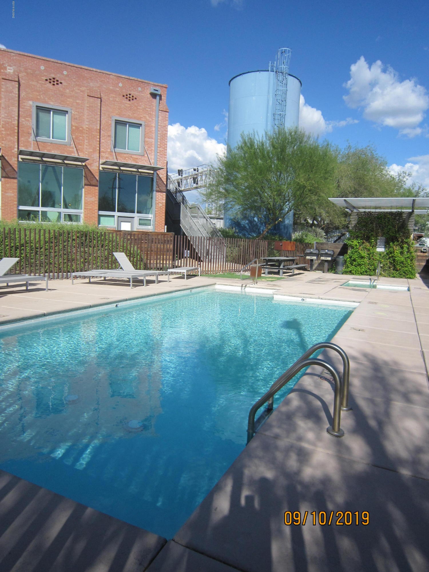 Fabulous Floor to Ceiling City and Mountain Views from this Industrial Urban 1 Bdrm, 2 Bath Ice House Loft with Exposed concrete walls, steel stairway, Corian countertops and wood flooring. Remote controlled shutters for floor to ceiling windows overlooking City Lights and Santa Catalina Mountains. Large balcony off living room. Surround System, Community Pool & Spa, Gated Complex for Security. Minutes to Downtown and UofA! Elevator Access to 3rd Level. Separate Storage. 2 Reserved parking spaces : 1 covered, 1 uncovered.