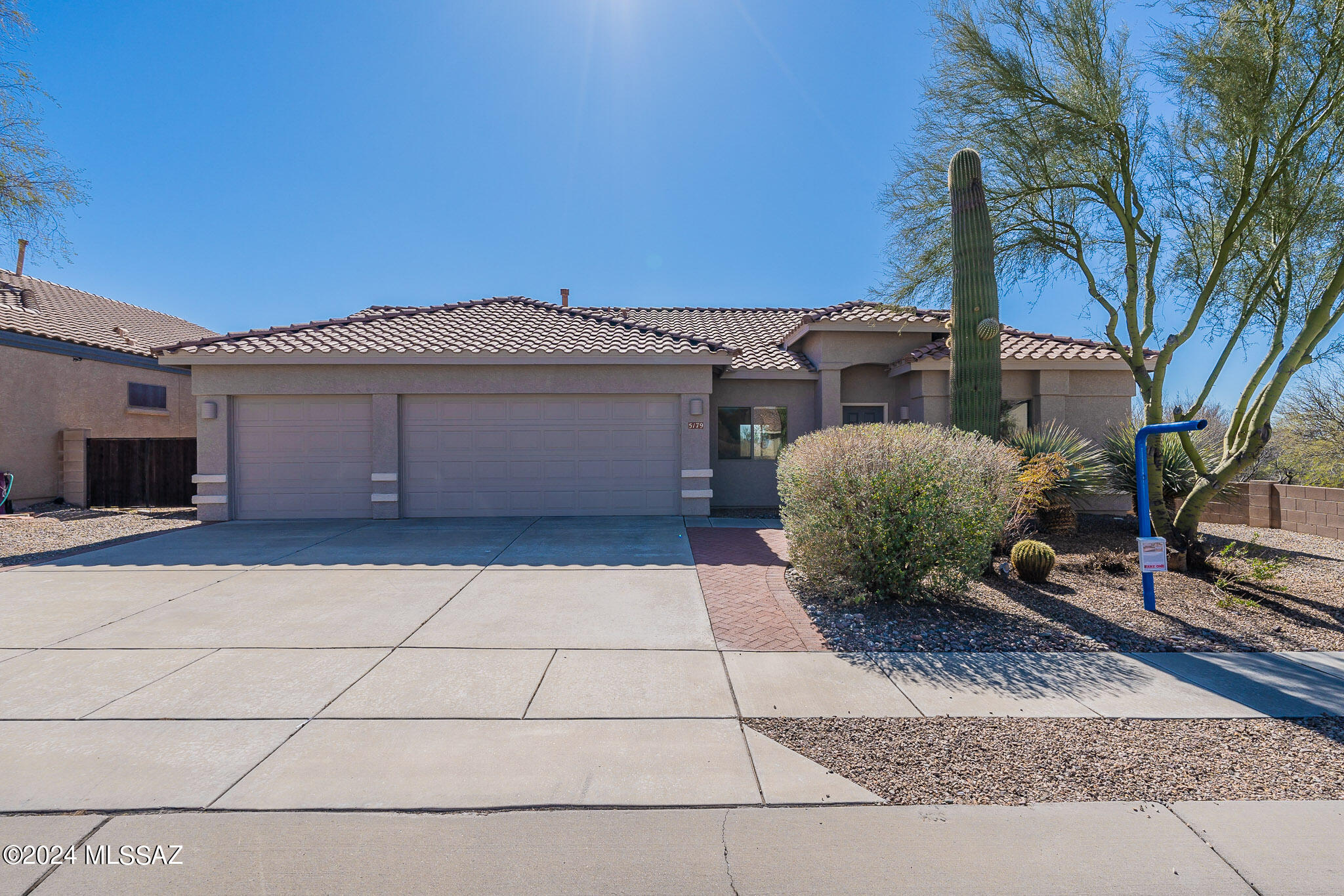 Meticulously maintained, unimpeded mountain and desert views, serenely quiet rear yard, privacy...a wonderful opportunity at an excellent price in prestigious Dove Mountain. With original owners, this home has never been on the market previously. A large living/dining space plus another great room with two large picture windows for a bright  and open look and den/office (this could also be a fourth bedroom), plus three handsome brick-paved patios, provide multiple options for relaxed living and entertaining. With a convenient split plan, the two bedrooms + full bath on the east side of the home are quite separate from the primary bedroom. The kitchen is decked out with cherry cabinetry, stainless appliances (gas stove), a full pantry and an adjacent breakfast room overlooking the desert. In the primary bedroom, enjoy views of mountains, desert, and a fabulously productive Meyer Lemon tree, with glass sliding doors to the back yard. The primary bath includes a walk-in closet, separate WC, shower and oversized tub with jets, double sinks and a linen closet. Outside, find a contemplative respite with a majestic olive tree, that incredible lemon tree and a pomegranate tree. Notice the lovely Italian Ragno tiles in a portion of the home, and the spacious custom-made storage cabinets in the garage (also spotlessly clean!).
With no neighbors in the back or on the west side of the home (commonly held property), you are assured privacy forever. The fridge and water heater are both two years new. The exterior was repainted in December 2021 and looks immaculate. The AC is five years new. Quick access to several excellent golf courses, the Ritz-Carlton, shopping (Both every-day and Marana Outlet Mall), excellent restaurants, and I-10 for Phoenix and the airports. HOA fees are only $67/quarter. You are invited to see this beauty today!