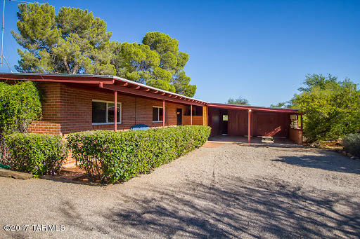 Classic Mid-Century Tucson. Masonry Constructed. Vaulted ceilings with exposed beams. Stained Concrete floors, with tile in kitchen, baths, and entry. Fireplace. Built in 1958, this home was last sold in 1968. You will be the third owner. Original footprint and floor plan with no funky additions. Refreshing swimming pool. Large screened-in Arizona room off the living room. Lots of patio space. Mature pomegranate trees. A sweet orange, and a bitter orange, perfect for Marmalade. Delicious Mesaland Water Company well water. The horse facilities haven't been used in years, but the corral and stalls are still standing, mostly. 1.81 Acres of saguaro-studded, Tucson bliss. Come check her out!