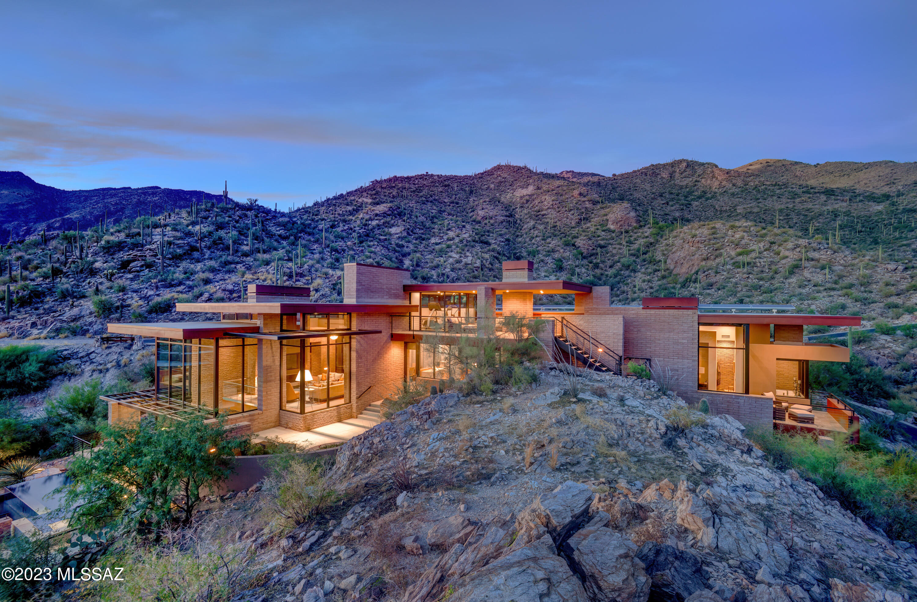 Top of the world views, sophisticated & incredible contemporary home on 2.5 acres overlooking city, mountain & sunset views at the top of the prestigious gated community of Ventana Canyon Mountain Estates. Award winning architect, Kevin Howard, designed home to blend w/ nature by building the home into the fabulous rock formations. The combination of natural stone, rusted steel & commercial grade windows creates the ambiance desired by the owners to enjoy a casual indoor/outdoor Arizona lifestyle w/ breathtaking views. Exquisite Greatroom w/ high ceilings, dramatic fireplace, floor to ceiling windows, limestone floors, incredible Baulthaup kitchen w/light gray anodized aluminum cabinets & finest appliances, breakfast area, formal dining room, 3 bedrooms w/ensuite baths + office, family r room w/ extended entertaining bar/lounge area, temp. controlled wine room, 2 powder rooms, laundry room, exercise room, elevator, and solar system in the main house(4889 sq. ft.) plus (382 sq. ft casita w/ 3/4 bath) & 3 car garage. Enjoy the gracious outdoor living w/ 2 spacious patios, BBQ area, gorgeous pool & spa, views, views, views!!!!! *** Lot 43, 6801 Hole in the Wall Way, Tax Code 114-03-117A is also included in the purchase price***