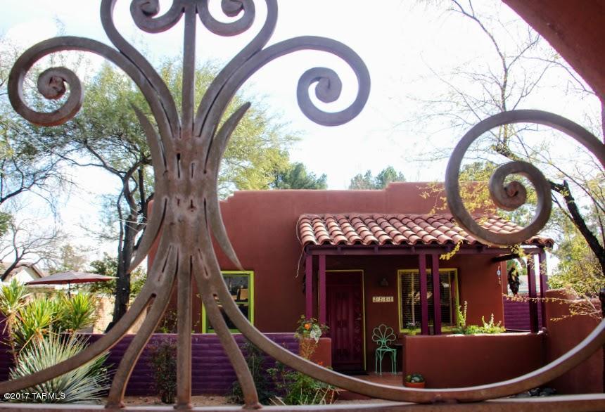 Darling adobe built in 1941, just oozes charm! Updated and artsy, this one will win your heart! Two bedrooms and a den/office flex space. Saltillo floors, plank & beam ceilings; this is a treasure of a bungalow. Walled front and back yards with custom metalwork make this a private oasis...and can be your urban farm dream! Lovely front porch and a shady back porch too.  Huge ''barn'' can be your workshop/shed/playroom, the oranges are delicious on your mature fruit trees, irrigation, there's even a patch of grass for the little one or dog to play in. Nice long driveway fits 2-3 cars tandem.  Located on a quiet sweet street with lots of lovely bungalows, this home is just minutes from UA/UMC.  BikeScore 83... VERY bikeable.  Whole Foods, the Loft, AZ Inn...just a few blocks away NOTE:  there is a desert tortoise who's lived in the yard for DECADES... and in summer, he eats the sweet grass (irrigated little patch)...or comes to the kitchen door for lettuce.