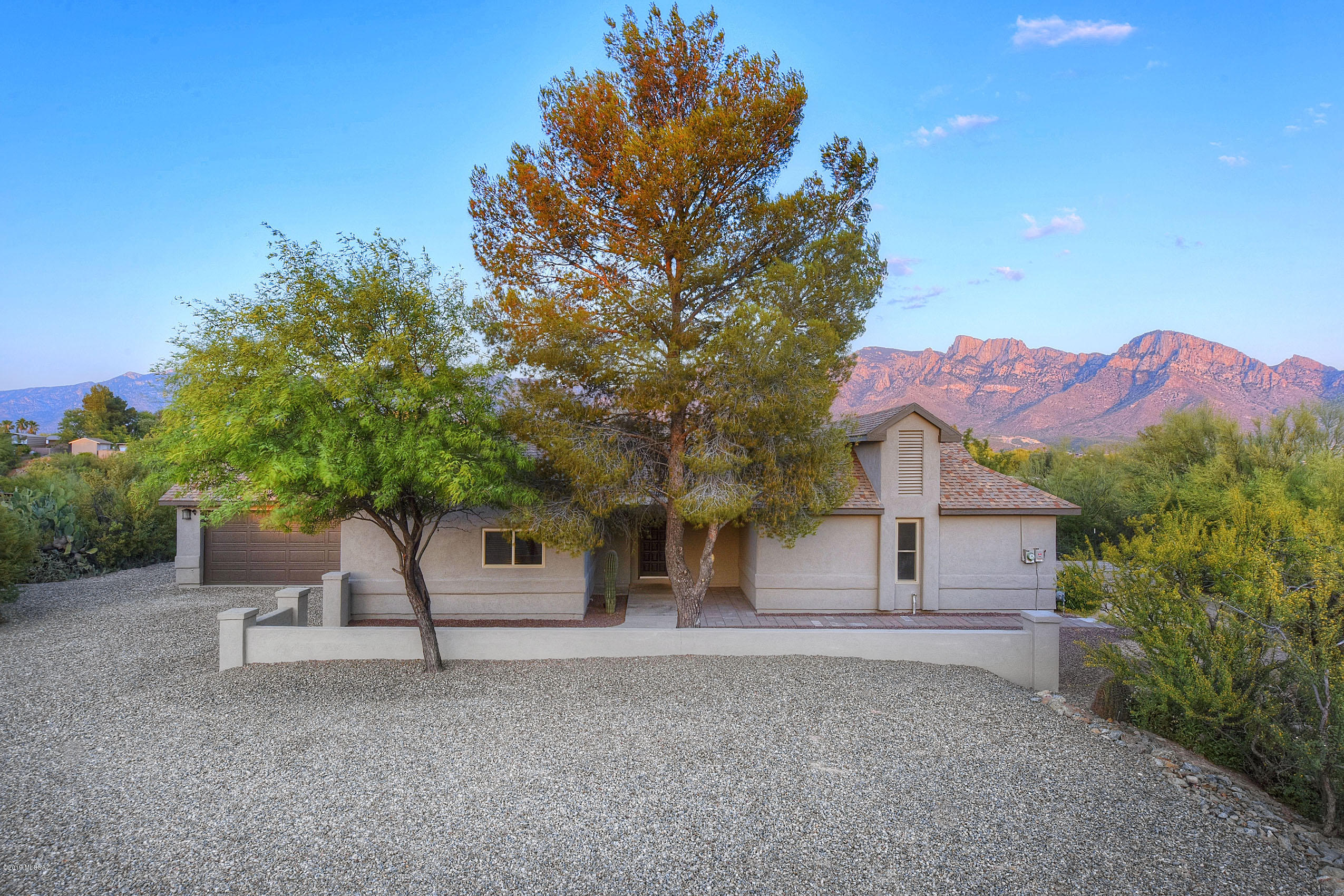 Outstanding full remodel on over an acre in the heart of Oro Valley! Unobstructed mountain views and welcoming courtyard entry. Stacked stone fireplace, wet-bar with beverage cooler, and vaulted ceilings. Elegant kitchen is an entertainer's dream with great workspace/storage, wall ovens, gas range, granite counters, soft-close cabinetry, large island, and several windows offering views and plenty of natural light! Split bedroom floorplan with two master suites and updated baths. Main master has charming sitting area with mountain views, French doors to back patio, huge walk-in closet, and ensuite bath with custom tiled shower and double vanity. Lots of closet space and large laundry room. Private backyard with expansive covered patio and endless possibilities - plenty of space for a pool!