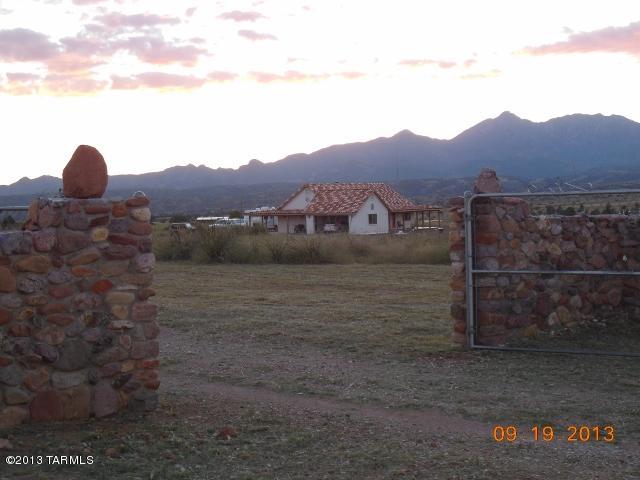 Native stone custom entry wall greets you upon entering this Quality built sparkling clean home with semi-wrap around porch. This property surrounded by jaw dropping views of Santa Rita Mountain range can be enjoyed from above ground hot tub. Terrific simplistic floor plan with ceramic tile flooring, distinctive tile roofing, interior arch ways, wood fireplace framed with tile. Wired for internet/satellite to all BDRMS & attached garage. Exterior Bose speakers can be enjoyed while relaxing under porch.  Private well, RV parking area & beautiful low care river rock & gravel landscaping enhance the grounds. Property is quickly accessible to town in a quiet low key atmosphere. A home just glowing with taste & comfort.