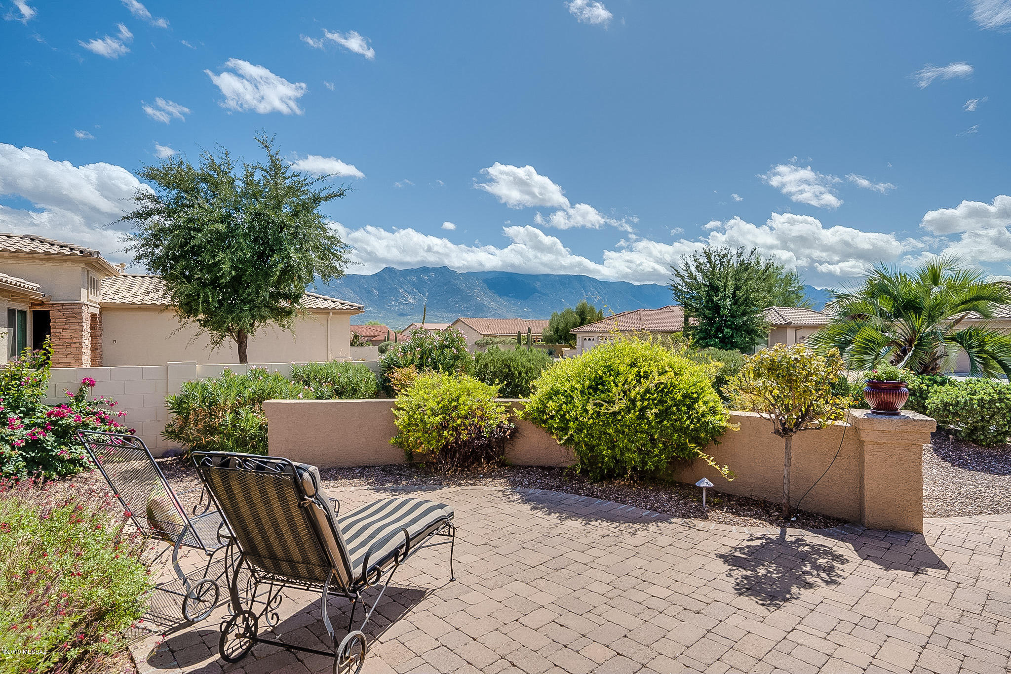 Walk up to this beautiful Laredo home with a paved courtyard, potted flowers, accent lighting & beautiful mountain views. As you enter, the great room has vaulted ceilings, tiled floors and plantation shutters. An open kitchen w/ breakfast bar, SS appliances, island, engineered stone countertops w/ an eat in kitchen and fabulous mountain views. A 2ft extension (east wall) makes the office with a Murphy Bed, bathroom, guest room feel very spacious. With a split plan, your master bedroom sits off the great room with plank flooring, neutral paint and a bayed out window which makes this your haven. The en suite Master bath with dual sinks has an updated shower, bright lighting and custom mirrors. Enjoy this large lot with an extended patio, lush landscaping & sparkling fountain.