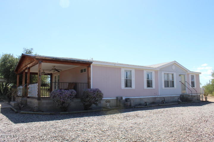 Country living at its best. This 3 bed 2 bath home has a sturdy covered east facing patio. Imagine enjoying the quiet, the mountain views and the beautiful saguaros or screen it in and create an Arizona room. Either way you are going to love hanging out here. Inside is spacious and bright with a modern kitchen with stainless steel appliances. Plenty of storage. Open airy living space with great views out every window.  Enjoy the privacy of a split bedroom plan. Walk out the dining room door to your completely fenced in yard and covered patio with cement slab. Don't forget to check out the 4 car carport and two storage sheds. One could be a workshop. There is also a fenced area with raised garden beds for the gardener in the family. All sitting on an acre with mature trees & many saguaros.