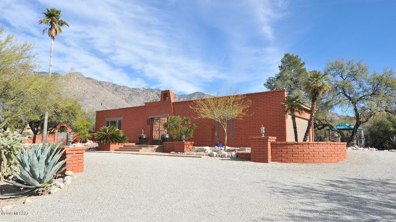 Charming Hilltop Territorial Casa set among Expansive Mountain Views. The Gated Courtyard features a Bubbling Fountain, Raised Planters & a Bell Tower. The Solid Carved front door opens to an Entry Foyer with Arched Windows & warm Saltillo Tiles underfoot. Polished Concrete floors, Beamed T&G Ceilings, Open rooms awash with light, a Huge Fireplace Wall & a Wet Bar in the entertaining areas continue that ''Old Pueblo'' feel with lots of NEW . All new Dual Pane Windows, New HVAC 12/2018, New Roof 1/19, New Plantation Shutters, New Pool, Kiva fireplace, Patio Wall 2013, New Interior/Exterior Paint, New Karastan Carpeting in Master Suite, New Sunsetter Awning over the Gazebo, Slate colored refrigerator. 4 Patios, Oversized Garage & set on .83 Corner Acres leaving room for expansion & privacy.