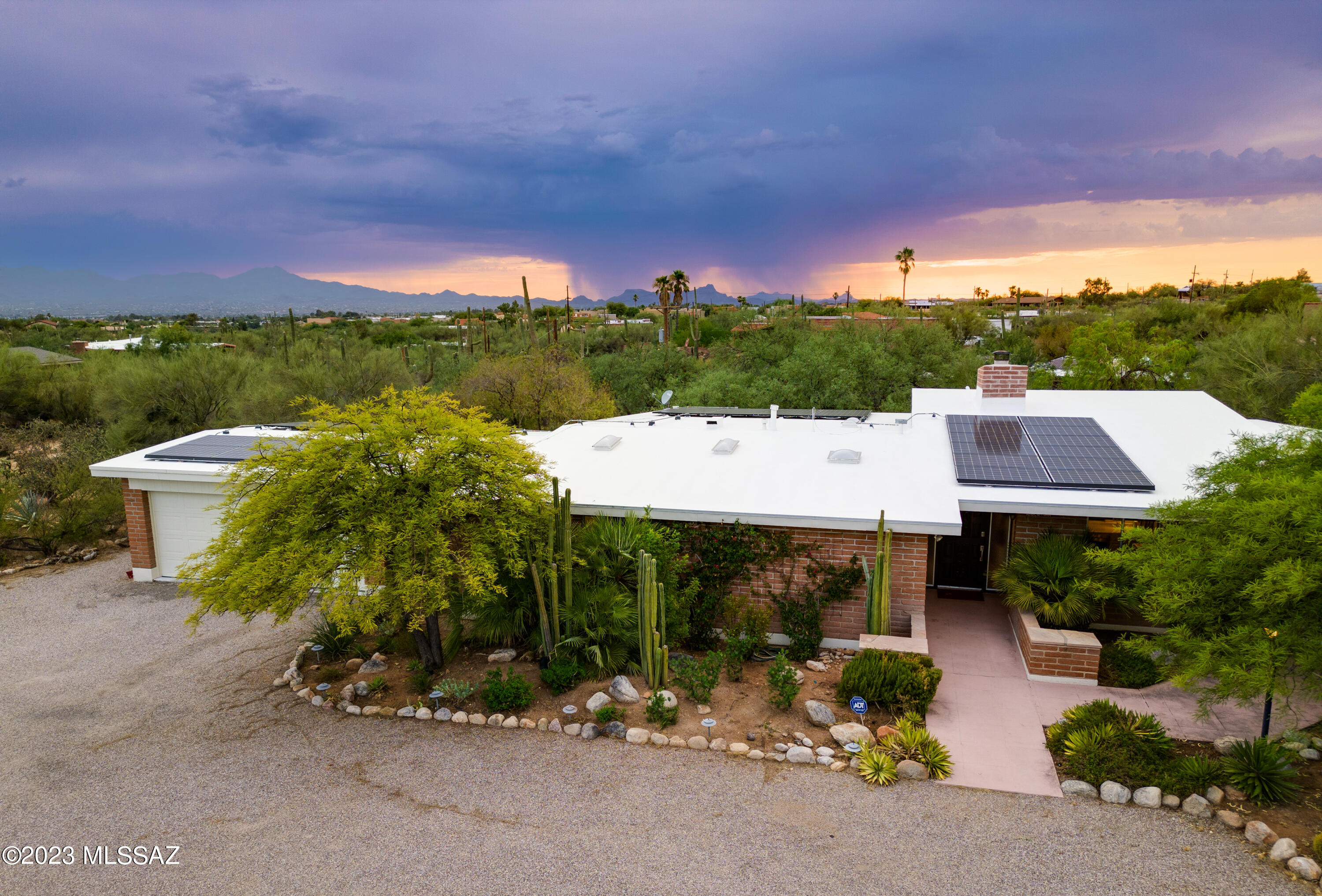 Stunning Territorial Meets Mid-Century Modern. Located on a beautiful 1+ acre lot with breathtaking mountain views, this striking burnt adobe Foothills District 16 home features 4 bedrooms, 2 bathrooms, an office, and a large family/game room. Open and bright updated kitchen with breakfast bar, stainless steel appliances, opens to the dining area with built-in buffet cabinet. Adjacent Butlers' Pantry and laundry room provide generous additional storage. Engineered hardwood floors were installed in all bedrooms, living room, and family room 5 years ago. Gorgeous living area with beamed ceilings, clerestory windows, floor to ceiling brick fireplace, modern and with Catalina Mountain views for days. This custom adobe home has great architecture-inside & out and was once featured in Tucson LifeStyle!

Primary bedroom with his and hers closets, walk-in tiled shower with multiple shower heads/sprays and north facing views of the Catalinas.

Roof was re-coated in 2021. Leased solar panels produce enough electricity to cover current owners usage and no additional out of pocket payments.

Located in District 16 schools, 2 car garage with attached workshop. Property has surrounding metal fencing, and mature natural landscaping throughout. Majestic mountain views and breathtaking sunrises and sunsets. Home is equipped with substantial storage space/closets, and this one acre lot has enough space for a pool. Close to schools, shopping/dining, hiking/biking/golf, easy access to UA, Downtown, airport, freeway, the loop. This special home will not last long - come and see it before it's gone!

Voluntary HOA