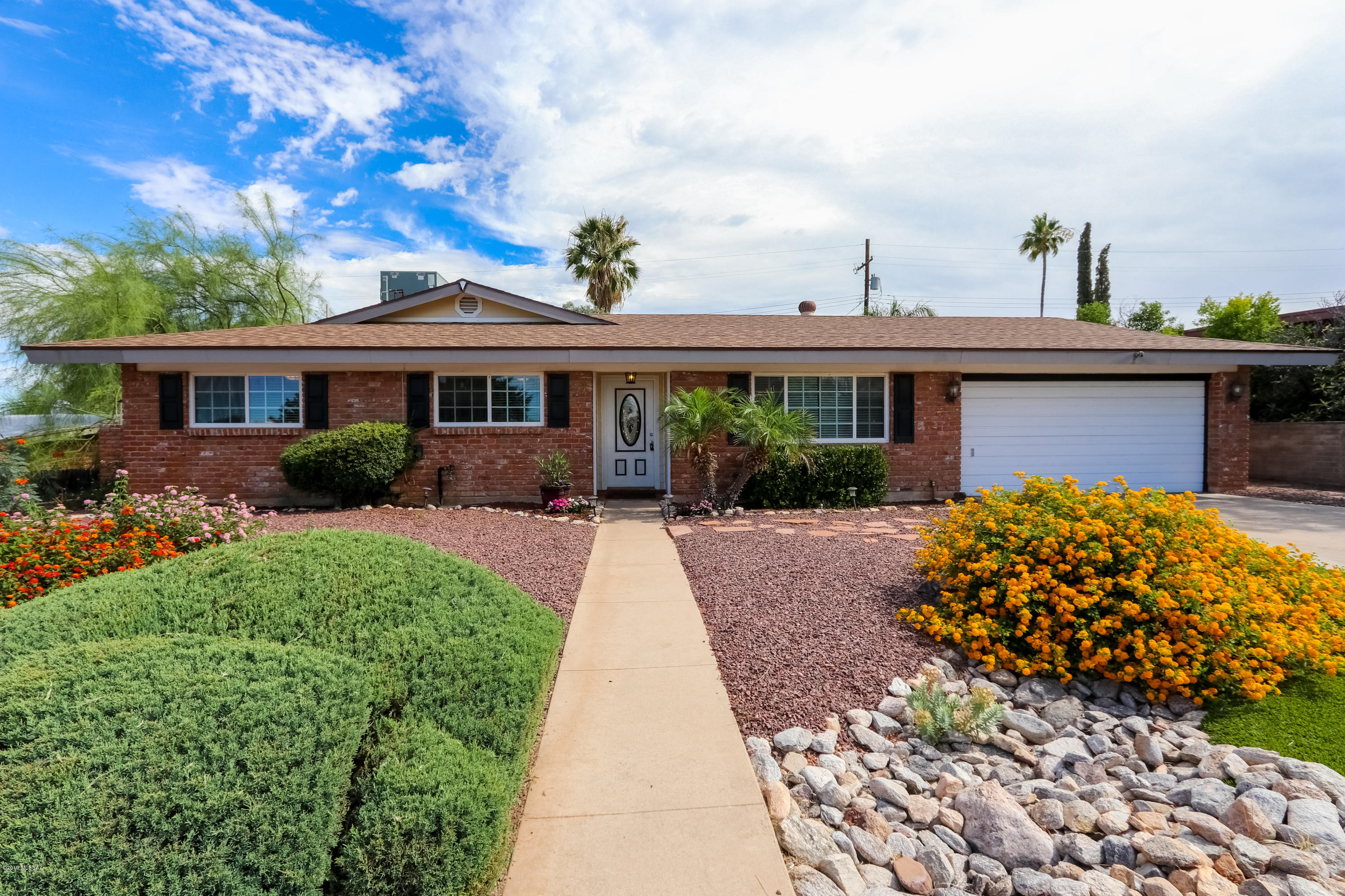 Honey Stop the car! This home just keeps giving...from the awesome curb appeal to the views, you don't want to miss it.  This charming east side home has been lovingly updated over the years.  Beautiful & over sized kitchen with an abundance of cabs, S.S. appliances, granite counters, breakfast bar, and wine fridge will please even the most discriminate cook.  Open floor plan is perfect for entertaining. Once the parties over...relax in the main bath spa tub or in the lush rear yard with mountain views. For the car enthusiast the two car garage with work shop area and storage is perfect for that weekend project. Wainscoting,  decorator colors, & a custom bath vanity are some of the decorator touches you will love. Don't forget the Eastern Hills member only pool is a short distance away.