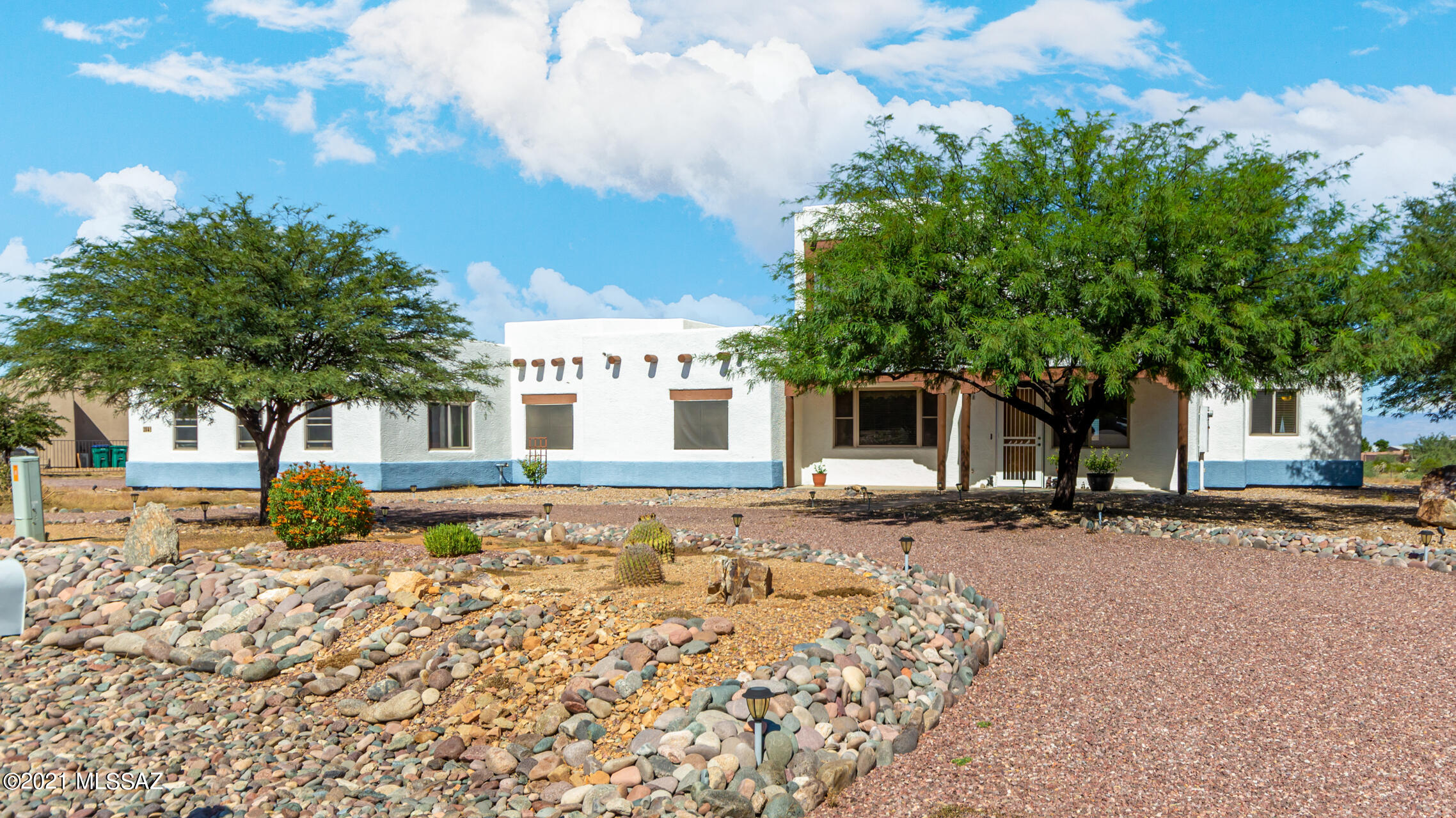Stunning 4 bed, 3.5 bath horse property with circular driveway, solar screens, & desert front yard is awaits you! Delightful interior w/a semi-open floor plan boasts neutral palette throughout, soaring ceilings, tile flooring, & a cozy fireplace with pellet stove insert. If entertaining is on your mind, you'll love this layout! Generous-sized kitchen offers ample wood cabinets, granite counters, stylish mosaic backsplash, peninsula w/breakfast bar, & high-end SS appliances w/wall oven. Primary bedroom has backyard access, a walk-in closet, & a private ensuite w/dual sinks. Guest quarter upstairs includes a living area, wet bar, bathroom, & a bedroom w/sliding doors to a wonderful balcony w/immaculate mountain views. Vast backyard comes with a covered patio & is blank canvass waiting