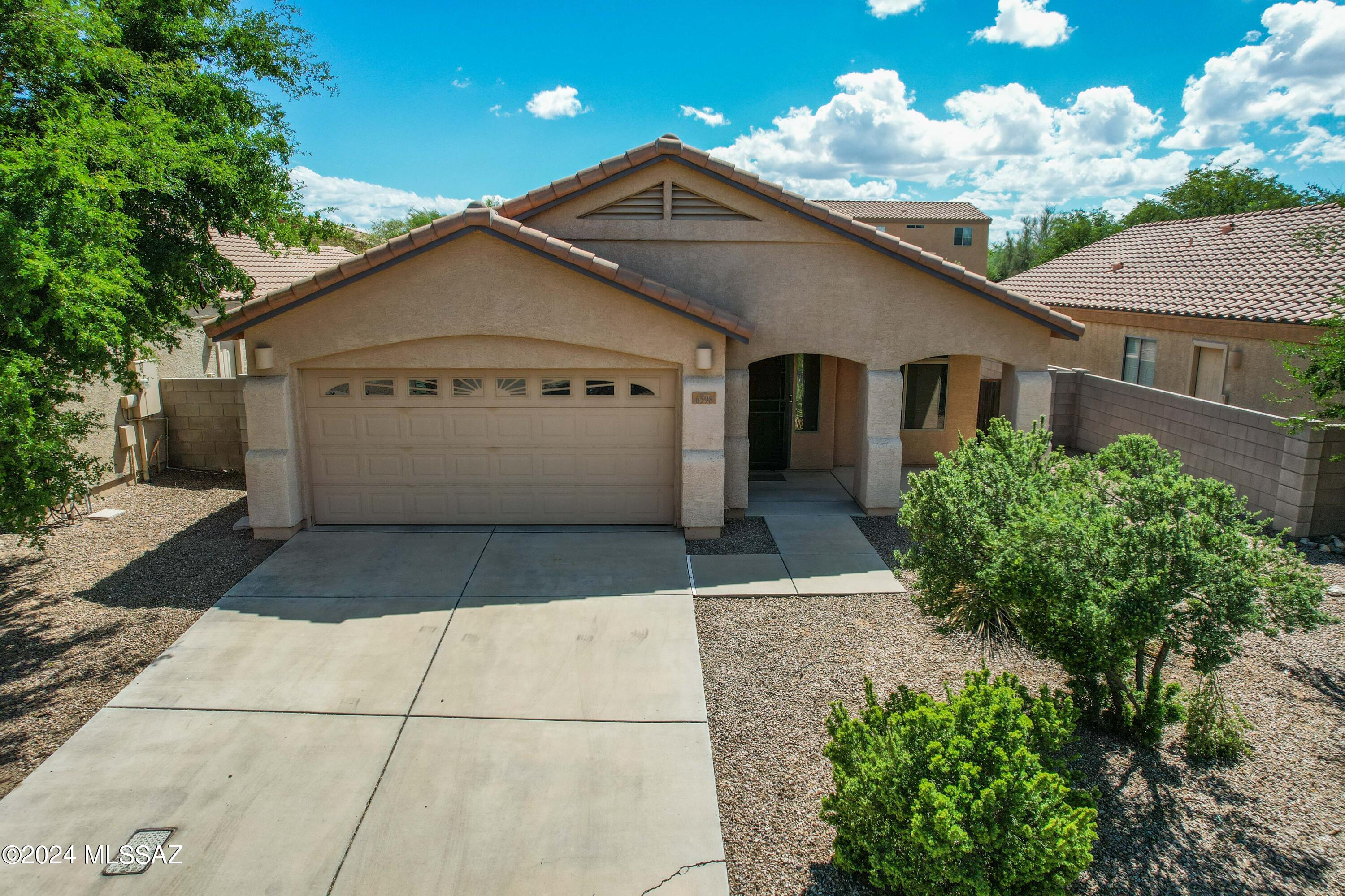 Beautiful 4BD/2BA contemporary home in gated community with exceptional amenities including pool & spa, workout facility, rec center, basketball court, playground & barbecue area. Two living areas are separated by the kitchen which has plenty of cabinets and counter space, breakfast bar, Corian counter tops and GE profile appliances, all appliances stay! Spacious primary bedroom with en suite; double vanity. High ceilings, roomy closets, carpet, enclosed backyard, covered patios, well taken care of and ready to move in.  I-10 access, convenient to Raytheon, Davis Monthan AFB, UA Tech Park. Come and take a look today!