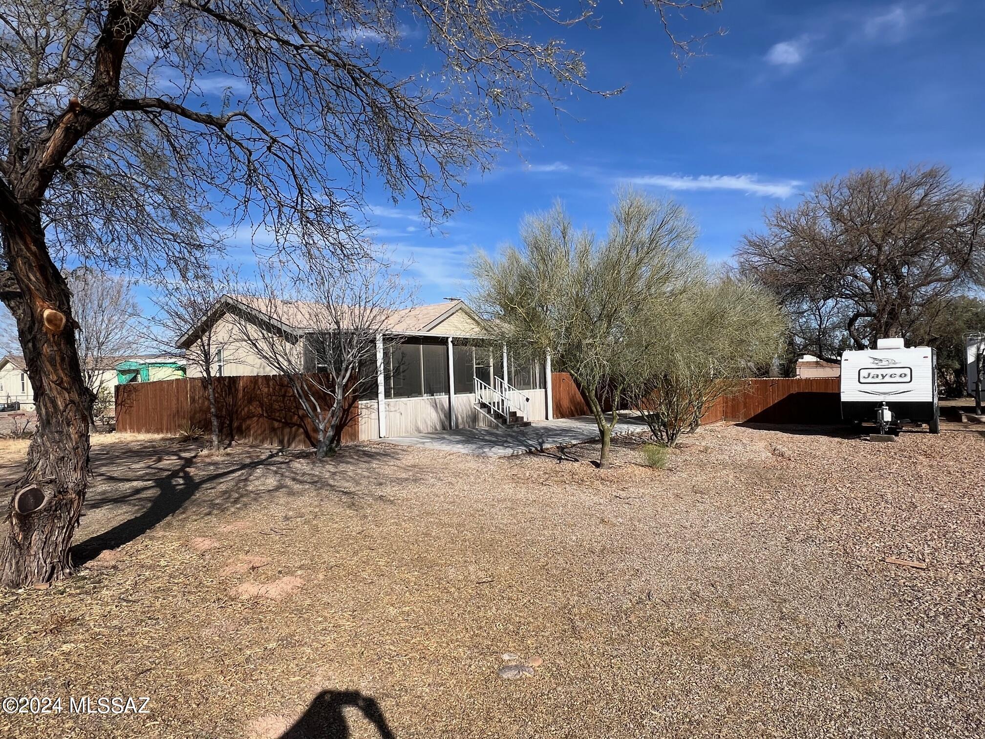 Centrally situated, near shopping and parks, this upgraded gem boasts a stunning front door, elegant countertops, ceiling fans, and artistic plant shelves. Featuring two bedrooms and a versatile office or art studio bathed in natural light from two windows.  Enjoy the  8 x 30 screened front porch. The private backyard, adorned with mature mesquites and pine trees, is fenced for tranquility, complemented by a covered patio and a separate deck for outdoor enjoyment.  Also includes parcel 123-20-069.