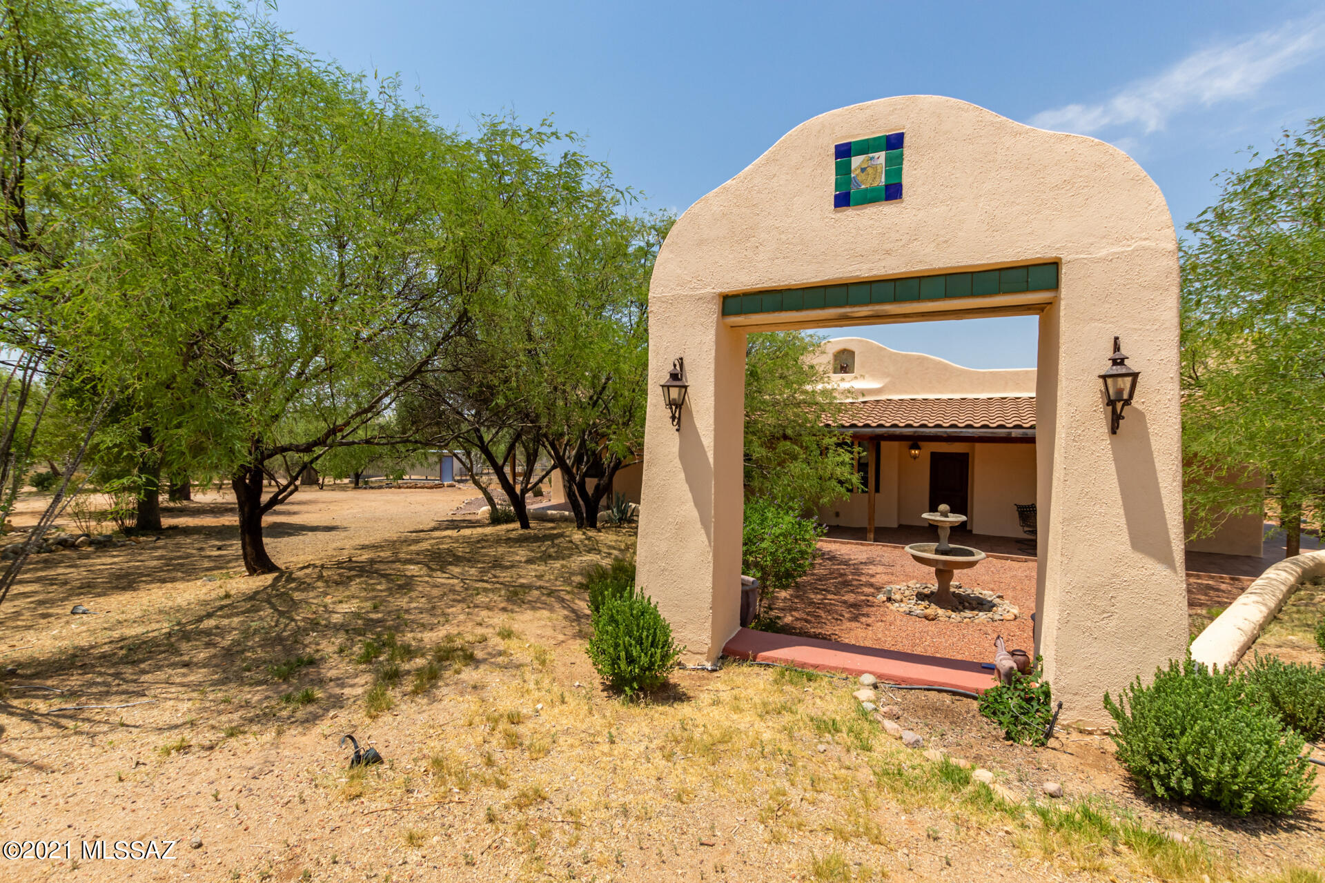 Iron gates lead the visitor up a gentle hill to a Spanish style home hidden from the road, graced by a beautiful walled garden with native plants and herbs and surrounded by mature mesquite, olive and ash trees.  On a 9.5 acre parcel with a private well, the 2BR 2BA home with 2,000 square feet has an additional 1,100 square feet of tiled covered porches for entertaining. 12-inch thick Rastra walls and Andersen double pane windows provide excellent insulation in both winter and summer.  Hand painted tiles and antique stained glass have been used throughout the interior and exterior.  The kitchen, with a Wolf 6-burner gas cooktop, a 4'x 6' prep island and quarter sawn oak cabinets with full extension drawers is a chef's dream.  Adjacent to the kitchen is a pantry with extensive shelving and a utility sink with a hand painted tile countertop. The bathroom in the spacious master suite is complete with an antique claw foot bathtub and hand painted tiles throughout the walk-in shower. Outside the eastern doors, a cast iron spiral staircase leads to a deck with panoramic views for outdoor dining and stargazing. The contoured property gives privacy to the occupants and unlimited possibilities for creative outdoor spaces. A 200 sq.ft. studio and small building for a pottery kiln are an easy walk under shady trees from the house. The property also has a carport for two cars, stables that were transformed into a workshop, an arena, horse stalls, and walking or riding trails.