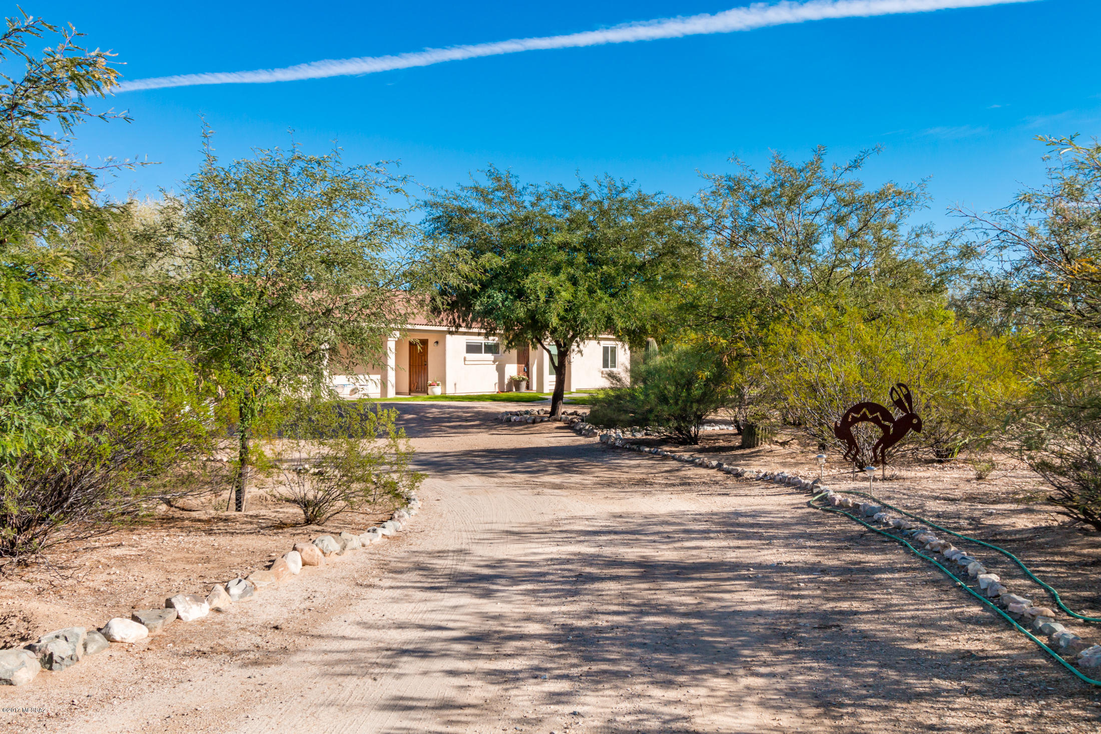 Live away from it all on this huge gated rural property in Sahuarita! The house sits on 4.75 acres, including a very large, completely enclosed backyard. The entire 4.75 acres is fenced with gates in three locations: the main driveway, the northeast corner and the northwest corner. On the grounds are two walking trails, perfect for peaceful evening strolls. Inside, the house is laid out in a split floorplan with ceramic tile throughout the living areas. The kitchen features alder cabinets with Corian counters and a gas range. The 2-car garage has an evap cooler. Also on property is a chicken coop that will convey. This home is a wonderful escape from the world!