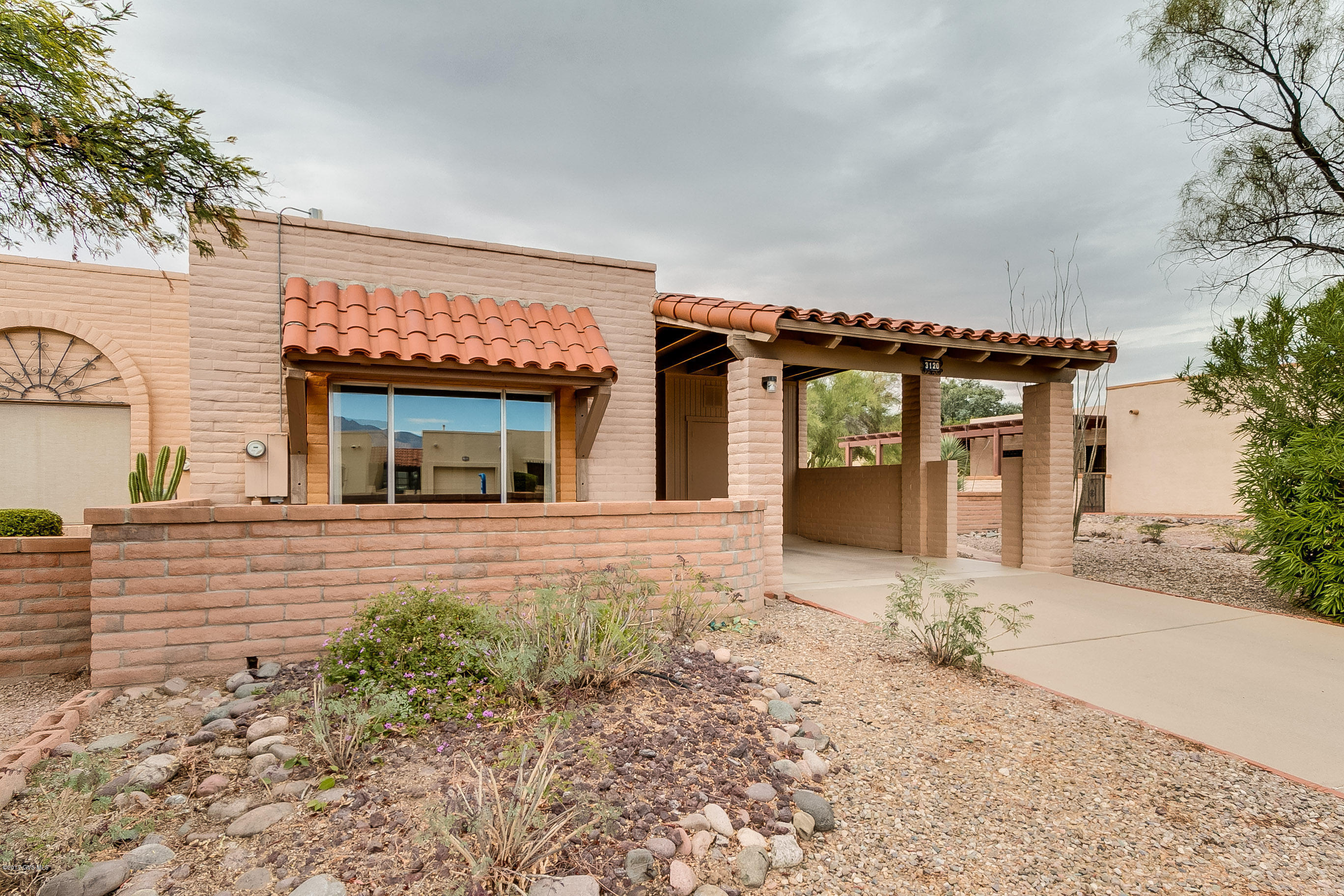 The perfect size winter get away with traditional red block construction. A curved wall courtyard and an open-air carport take you to the cross-breeze steel front door. You'll enter a classic floor plan featuring a traditional living room with two large windows catching views of the Santa Rita Mountains. The kitchen features hardwood oak cabinetry with easy clean laminate countertops accented with a country home theme. An open dining room is just across the hall and provides a convenient wet bar tucked away behind folding doors. Step out to the back patio where the extended shady roof top reaches out to a low maintenance yard with its centerpiece mesquite tree. Just relax and enjoy your own piece of the desert southwest.