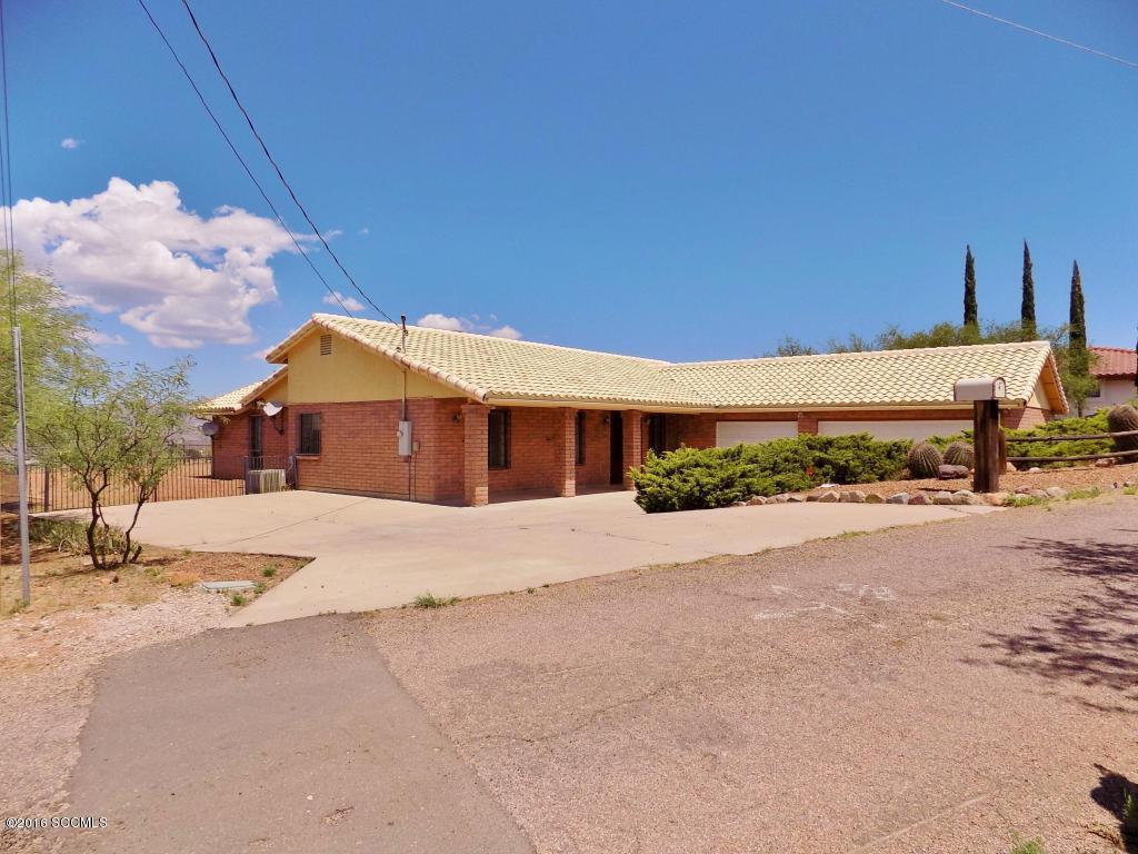 Lovely ranch style brick home with tile roof. Large yard to store or have pool or guest house. Great mountain views! Vaulted ceiling and open floor plan with large 3 car garage. Two way wood burning fireplace. Arizona room not heated and cooled and not on sq footage. Removable wrought iron on all windows. Basic home warranty plan and termite warranty. Great area with easy access to 1-19 and Rio Rico community center and fitness & walking trails. Needs some updating but great value for price!