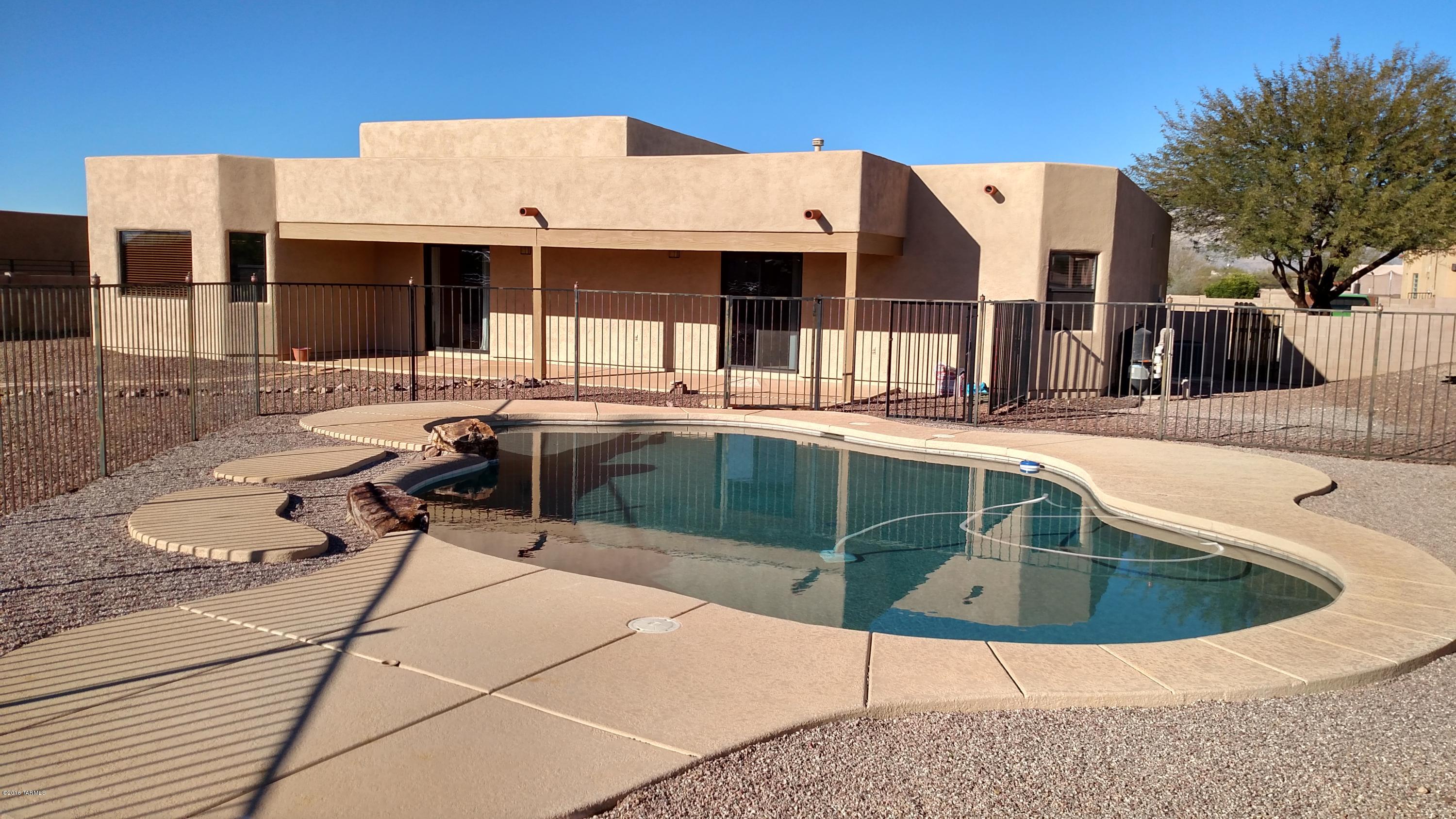 Gorgeous pool, spacious back yard w/double gate access all backing up to natural desert plus a beautiful home, you CAN have it all in one place! New carpet in bedrooms & living area, tile everywhere else. Lots of cabinets w/pullouts & ample counter space in kitchen with maple cabinets & custom tiled backsplash. Master bath has 2 separate executive height vanities, garden tub & walk in shower.  Sliding door at the master & living area takes you to full covered patio & out to pool.  Great room floor plan w/breakfast bar. Bedrooms 2 & 3 oversized & set apart from master. And don't let the garage fool you, it is a 2 car door but is almost as large as a 3 car inside w/built in storage shelves, soft water loop & 220 outlet! Make it your workout room, workshop, game room, etc...