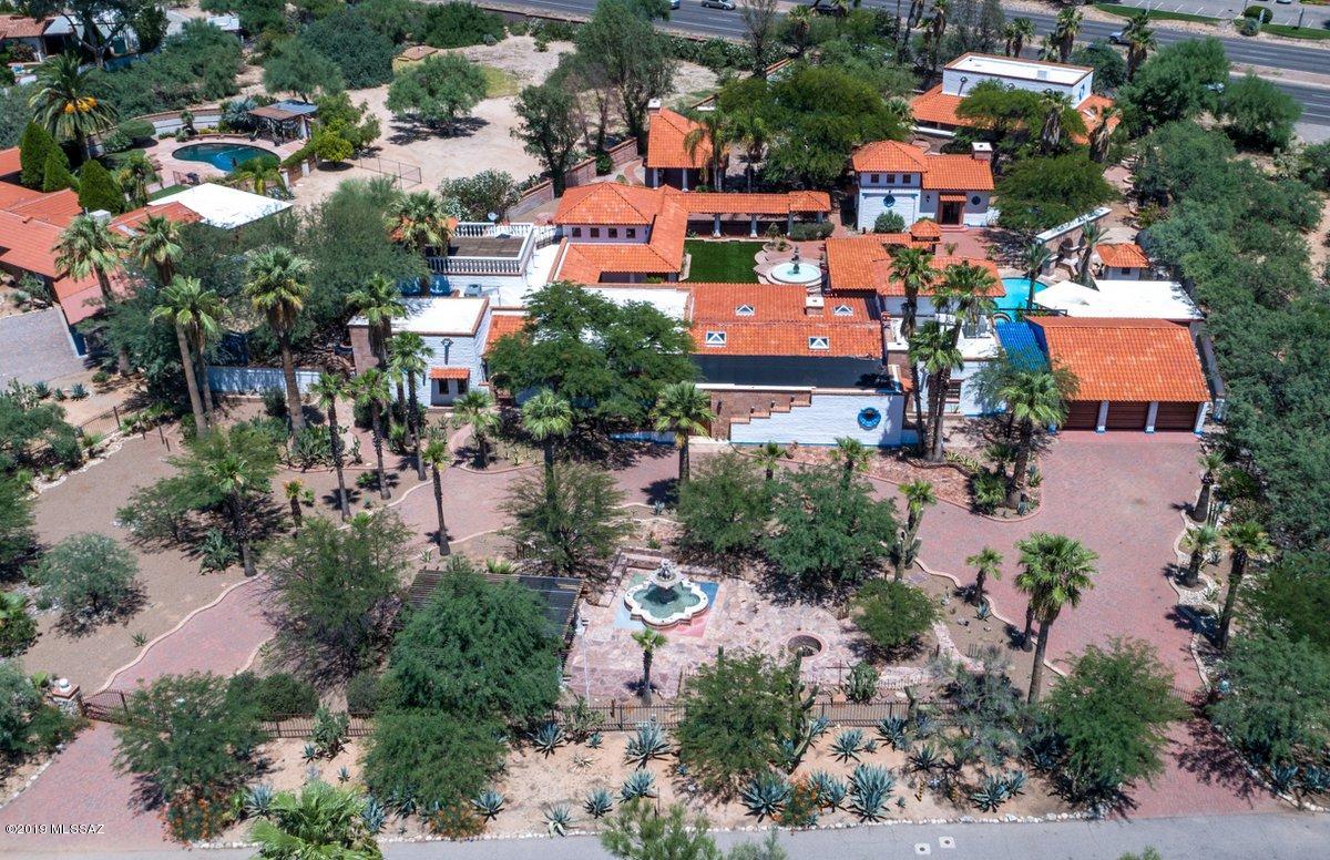 Old World craftsmanship abounds in this gated Casas Adobes estate. 5 bedroom main house features all new Vein-Cut Travertine floors, freshly remodeled bathrooms & extensive Mesquite built-ins & paneling. Re-designed kitchen now features Calcutta Quartz countertops, 36'' Viking Range, Stainless hood & Viking Dishwasher. High wood beamed ceilings throughout, Massive master suite with exquisite his & hers baths, Swedish spa room, with Steam Sauna, shower, Spa with Swim-Jets & viewing deck. Truly a park like setting with Front and rear fountains, entry courtyard with streams & fountains and Two Rock waterfalls with meandering streams flowing into amazing fishpond adjacent to outdoor kitchen featuring Massive grill, fridge & huge Rotisserie oven. Owner/Agent Pay special attention to the custom touches you wont find anywhere: 16" adobe construction, Solid mahogany garage doors w/ copper inlay, stained glass doors & windows and Custom Ironwork through-out. 1 bedroom guesthouse with Mesquite cabinetry, 15' ceilings & fireplace Sparkling pool w/ Pool bathroom & outdoor shower Additional features include an indoor sport court, resurfaced basketball court, greenhouse, commercial playground, workshop, Exotic bird enclosures, iron dog kennels and 6 car garage.