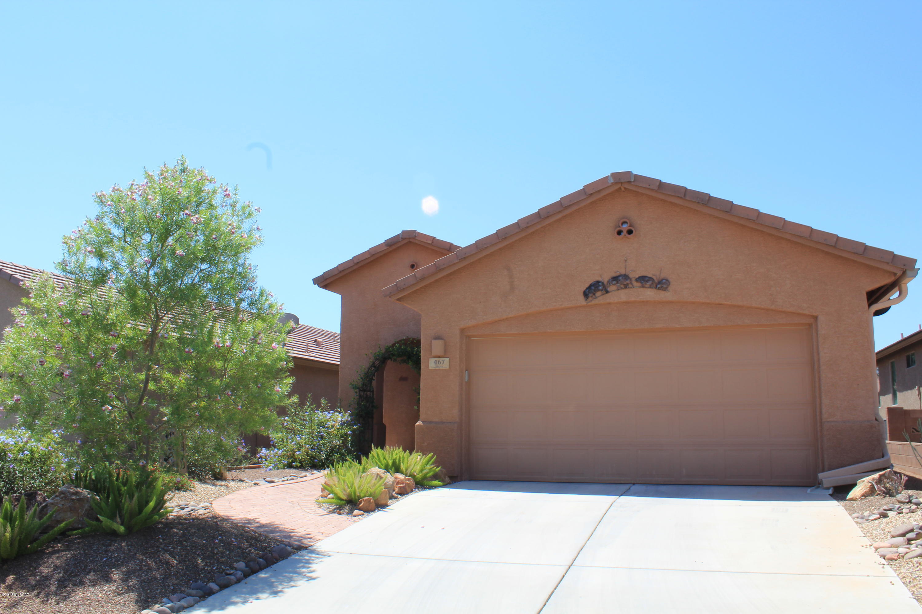 The front entry will greet you with colorful shrubs and a jasmine-covered archway. Enter through the front living room that could be an office/bonus room.  The great room offers open space while the chef is cooking to interact with visitors. Step out to the back patio for a peek-a-boo view of the mountains and listen to the relaxing fountain. Back inside the master bedroom is large and the master shower has modern tile. The walk-in closet has built-ins with drawers and shelves. The cozy guest room is fresh and inviting with the white wainscoting and soothing wall color and has a walk-in closet.  On the way to the garage you'll walk through an office space with desk and cabinets. Close to library, GVR rec centers and businesses. Some furniture available separate bill of sale.