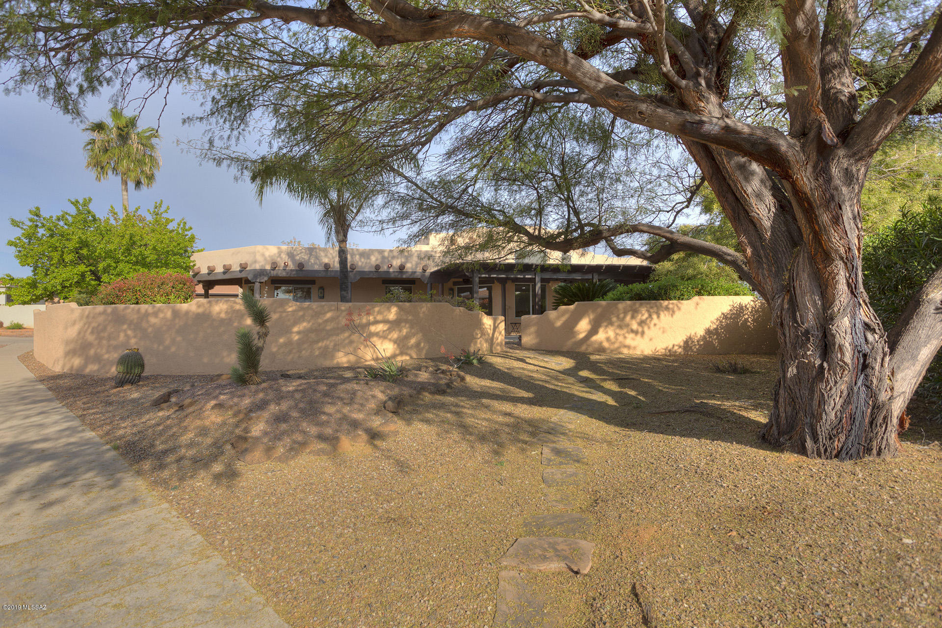 If you love privacy and want your own nature sanctuary take a look at this custom Santa Fe in the heart of GV! You'll enjoy the large covered patio area wrapped around the east side of the house as you listen to the trickle of the water feature and hear the birds sing. You'll be sheltered from the sun under the all-weather ramada. You may notice the falcon, the hummingbirds and the quail. Inside a custom arched mesquite wood door takes you to the bedroom area. The great room features high ceilings in a bright setting. With ceiling fans in every room, you'll be kept cool in the summer. A new HVAC was installed in 2018 for improved energy efficiency inside as well as a mini-split for the garage to keep it heated and cooled.
