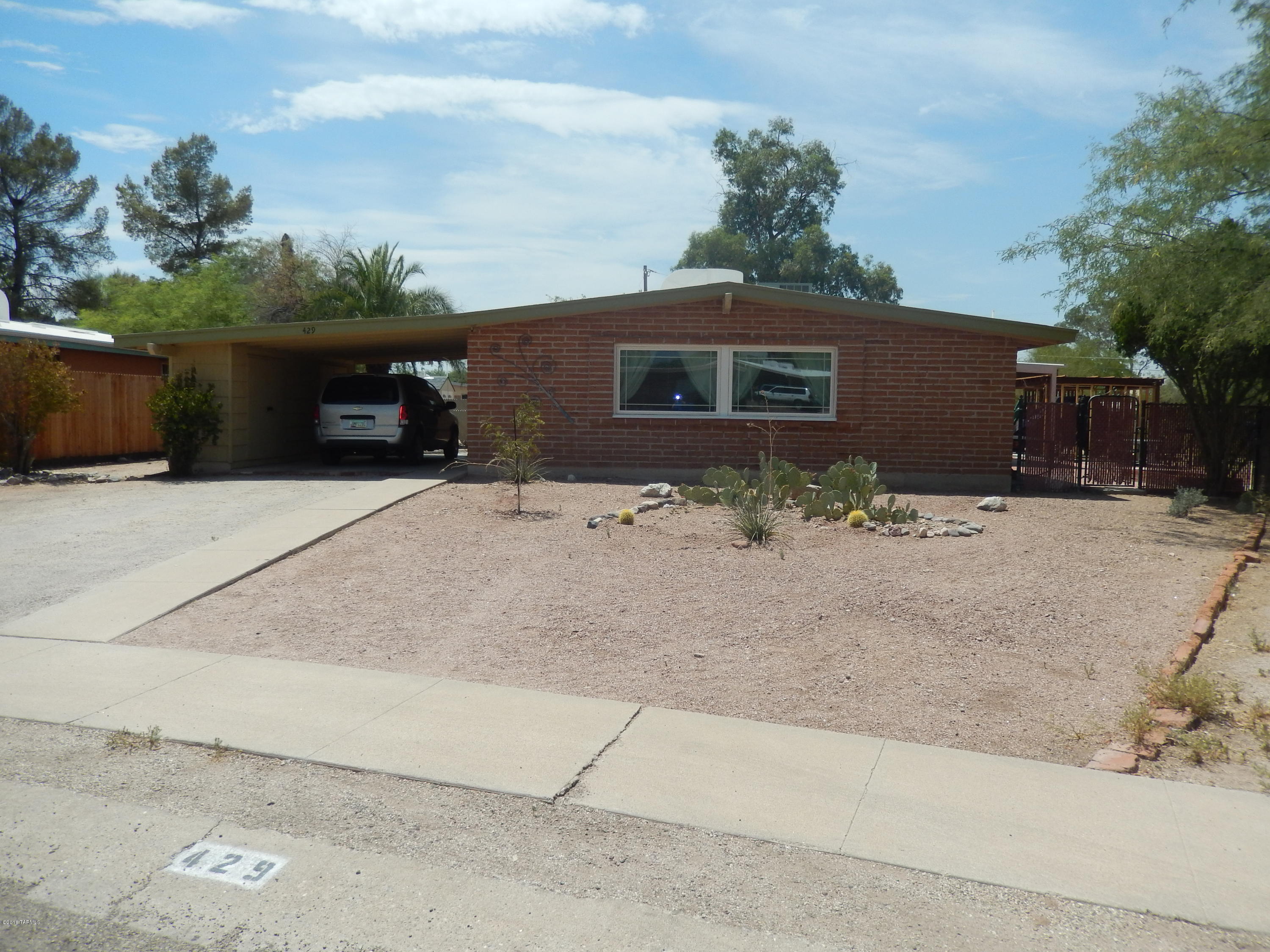 Newly remodeled home in East Tucson on almost half an acre! Tiled entryway leads the way to a beautifully remodeled kitchen w/ Quartz countertops, new cabinets & hardware, SS appliances, butcher block top @ breakfast island, Subway tiled backsplash & new Moen fixtures. Low E dual pane windows let in natural light & enhance the dark wood laminate flooring in kitchen, dining & hallway. R/O & water softener system has been installed. Baths have been updated & tub @ hall bath has been re-glazed. Rheem low energy ac/furnace installed in 2009. Water heater installed in 2012. Roof re-coated in 2015. Enjoy your large back yard w/ fruit trees, pavers, covered patio & large gate at alley for access. Exterior stg @ carport w/ electric & shed in back yard. Curtains in kids bedrooms will not convey.