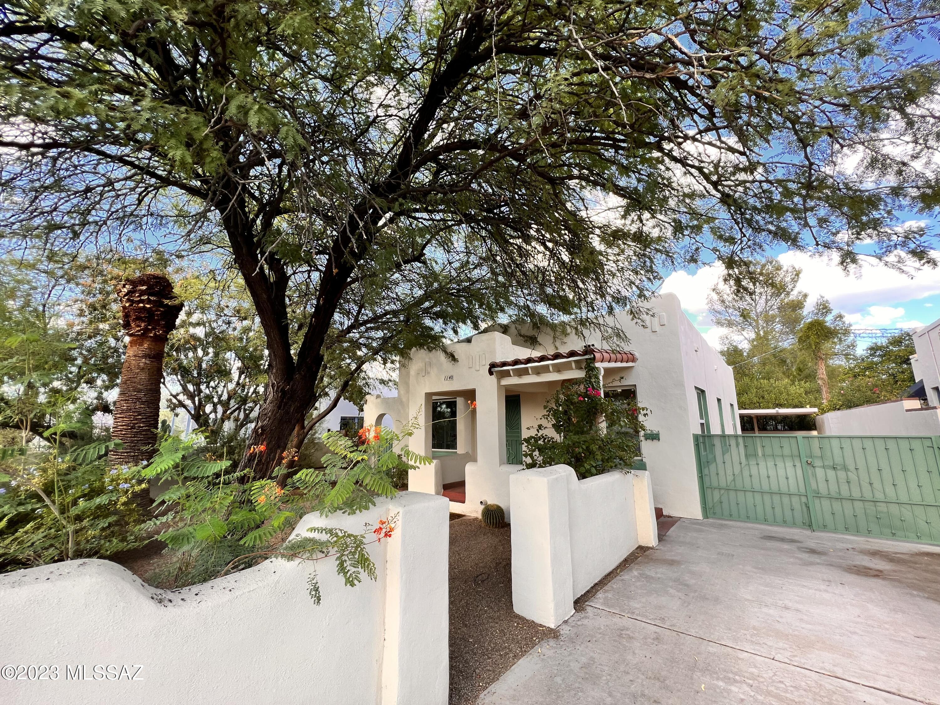 Don't miss out on this Charming Santa Fe Bungalow in central Tucson! Minutes away from University of Arizona, UMC/Banner Hospital, downtown, I-10 freeway, restaurants, shopping, & so much more! Front offers stucco wall yard with beautiful desert landscape. Pathway to front patio with metal security door at entry, welcoming you home to a fireplace & lots of light through beautiful custom-made stained glass window features. Hardwood floors throughout that walk you past dining room up to open-concept kitchen overlooking living room -perfect for entertaining. Kitchen has lots of counter space with windows + skylight that fills the space with lots of natural light. Past the kitchen is a den with access to backyard & primary bedroom. Carport in back for secured covered parking plus shed!