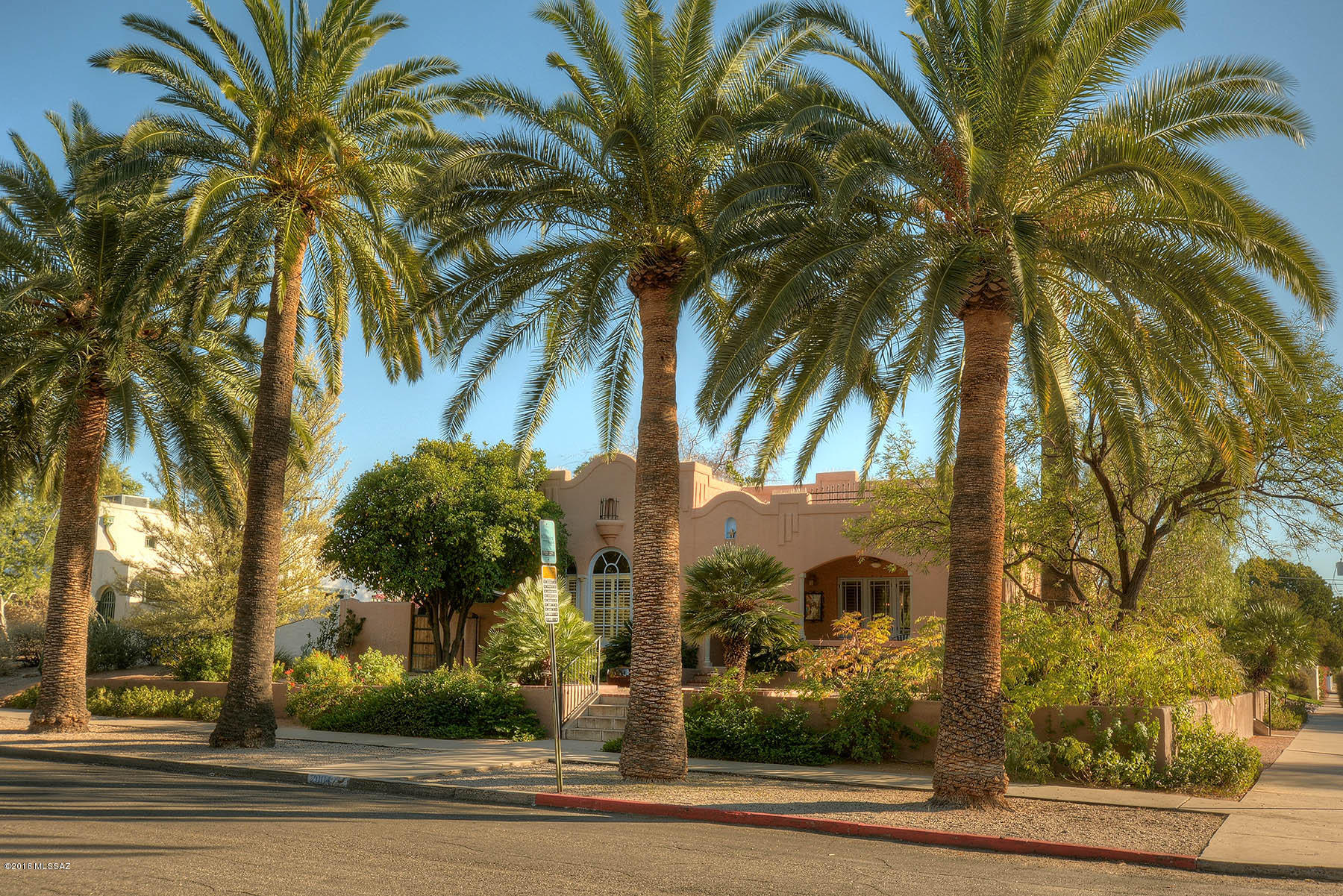 A GEM 4th St. corner lot home in the highly desirable University Manor section of Historic Sam Hughes. Immaculate, with beautiful large arched windows and coved high ceiling. Custom shutters and wood floors throughout. Extensive recent remodel now provides modern, energy-efficient electrical, irrigation, and water systems that are wi-fi compatible. Features excellent, well proportioned floor plan. Luxurious, mature landscaping, with covered front porch; back brick patio area offers lovely private entertaining. 161 SF studio and 339 SF basement. (Basement not included in house SF). Great cycling neighborhood, 3rd Street designated Bikeway, with easy walk to Link Streetcar, U of A, Main Gate Square, University Starbucks, Rincon Market, Himmel Park (pool+library) and Banner (CLICK MORE) Medical Center.  Street-entry 2 car garage, 2 driveway parking spots, plus 2 street parking permits.  A true Sam Hughes jewel!