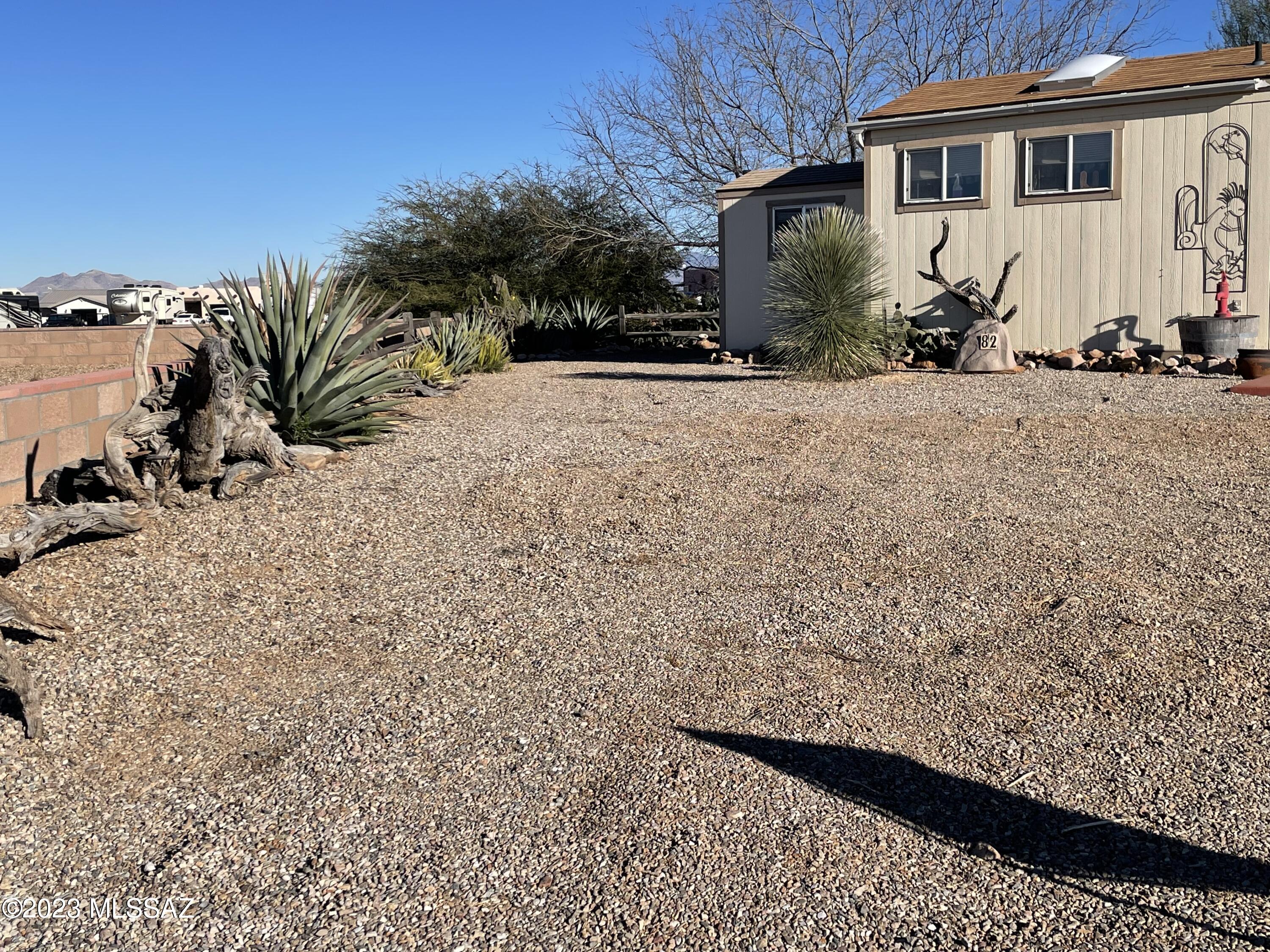 Prettiest lot in the park! Beautifully landscaped lot on cul-de-sac in Az Legends. Already has slab, a casita building, complete with washer/dryer, half bath, heating, tvs, ceiling fan), separate tool shed (with electric) and large heavy duty awning. Lot is ideally situated and has a convenient entryway to park walking trails that connect to the clubhouse with all its amenities and just needs your rv or park model! PRICED TO SELL - call for an appointment before its too late.