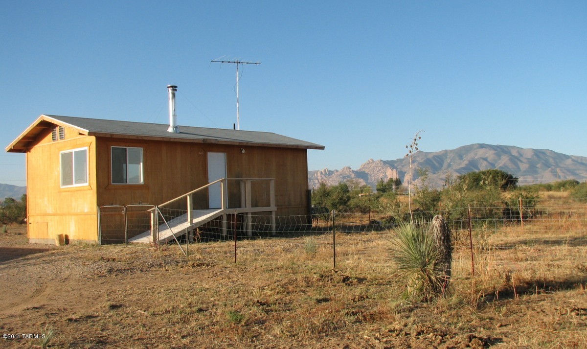 Almost finished !  Cute bungalow with full bath.  Kitchen needs cabinets but has sink and hot water heater !   House built  by previous owner to code and fully inspected by County.  Must haul  water or drill a well.  Electric at property line but not run to house.   Perfect RV winter spot...awesome views of the Dragoon Mountains and Cochise Stronghold !! Property is not finished therefore is being sold AS IS..  No SPDS.  CASH ONLY SALE.